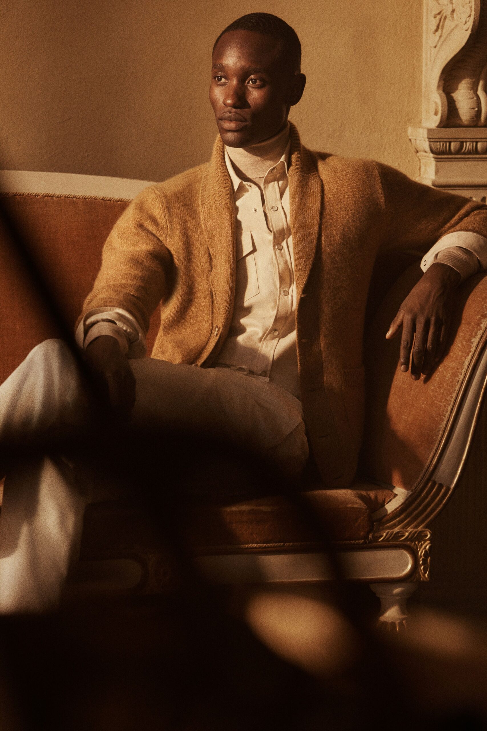 gold cardigan white shirt beige pants