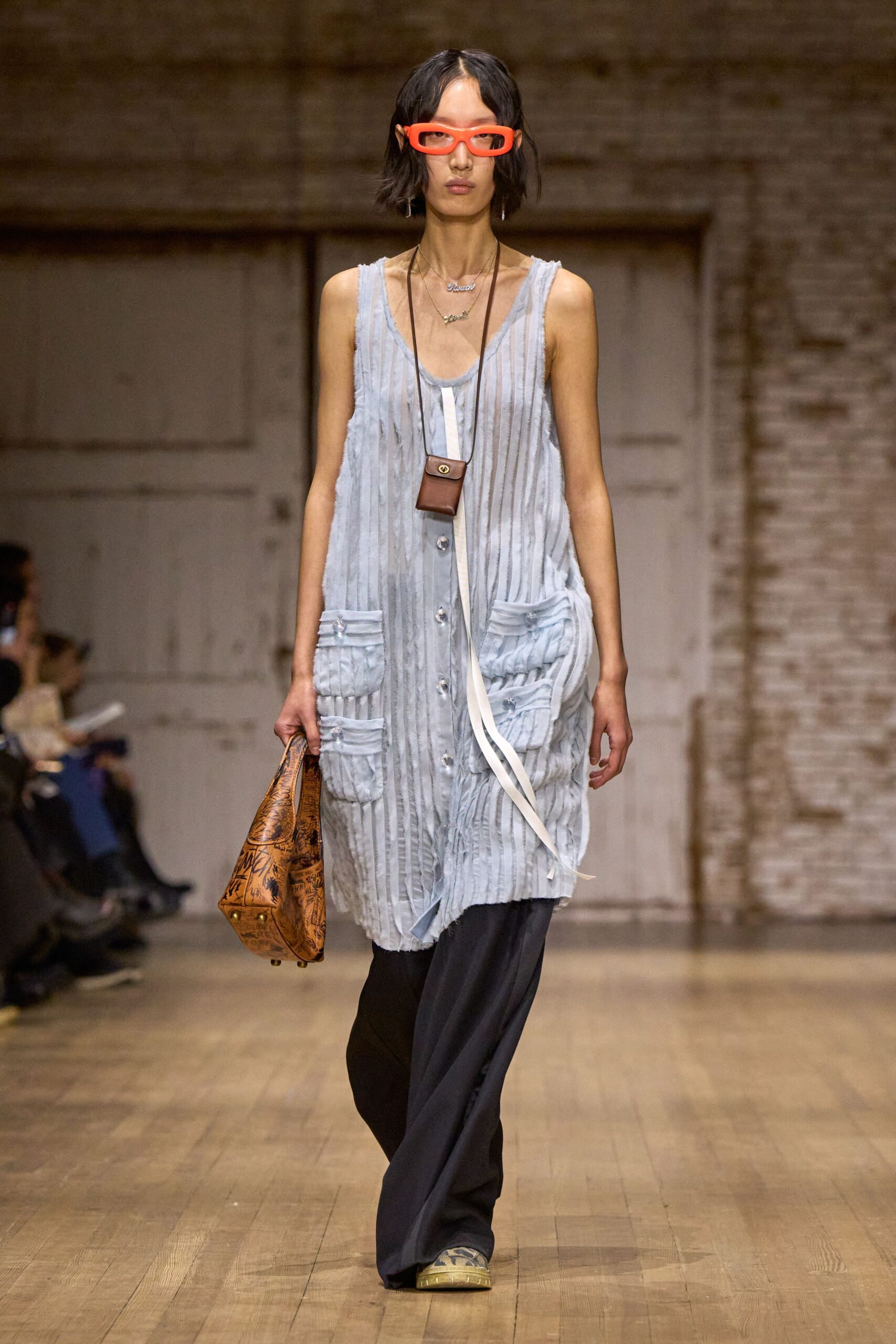 blue pleated sleeveless top with black wide-leg pants