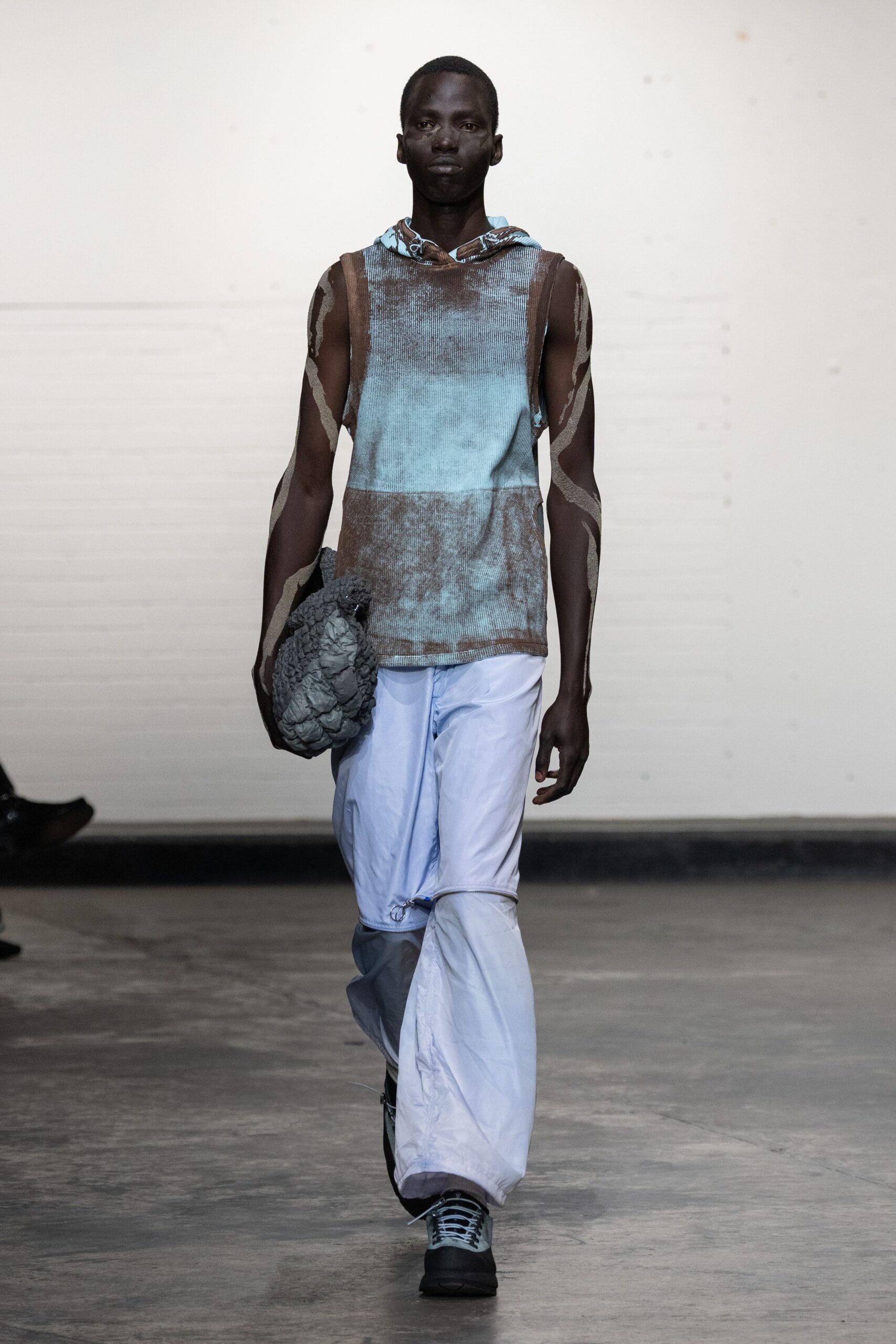 blue printed sleeveless hoodie with white pants
