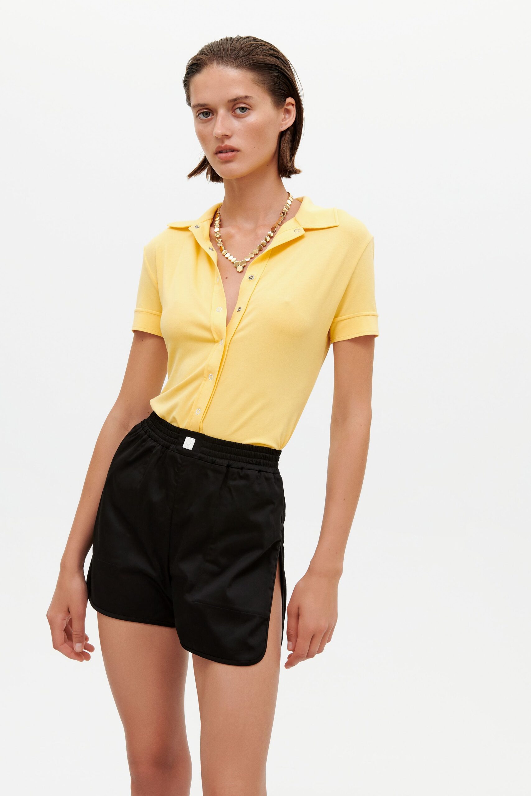 yellow fitted shirt and black shorts