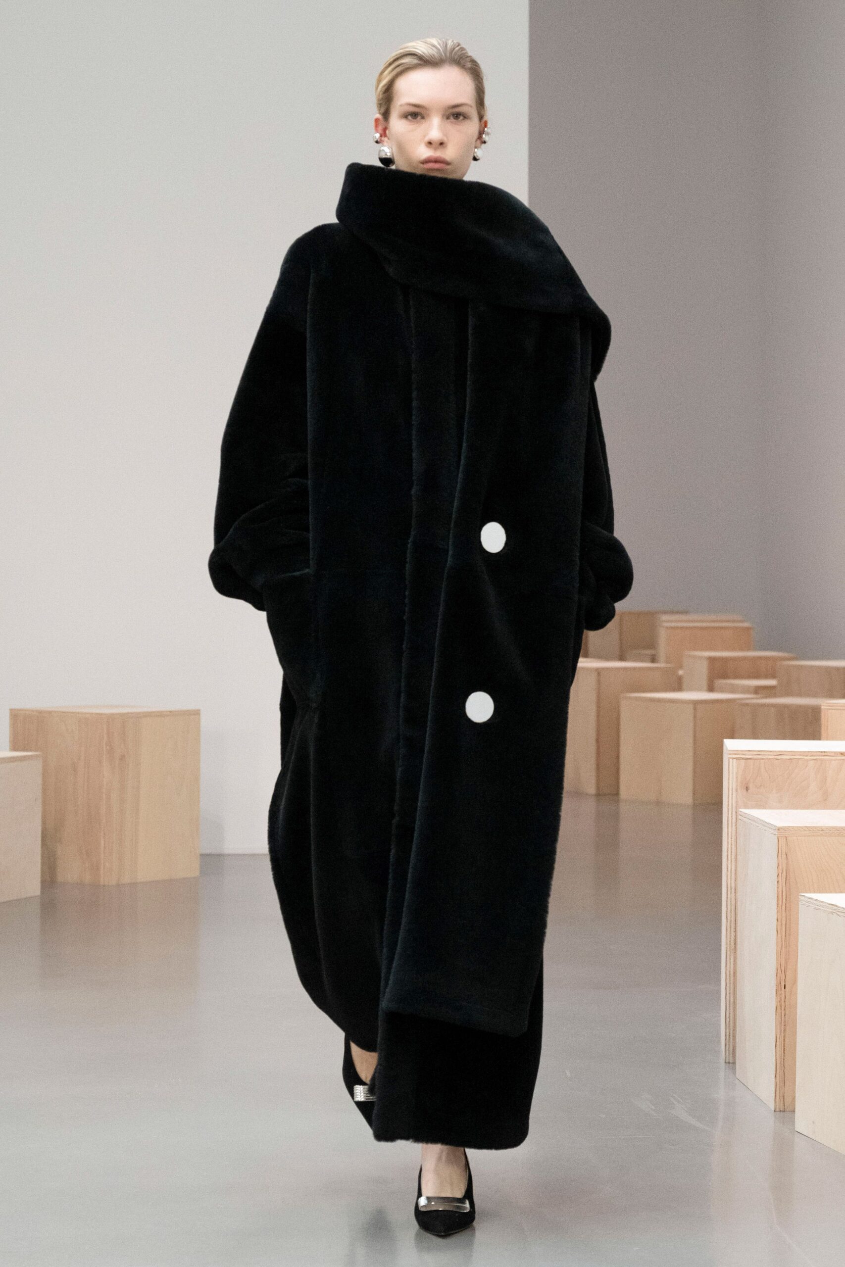 oversized black faux-fur coat with pointed shoes