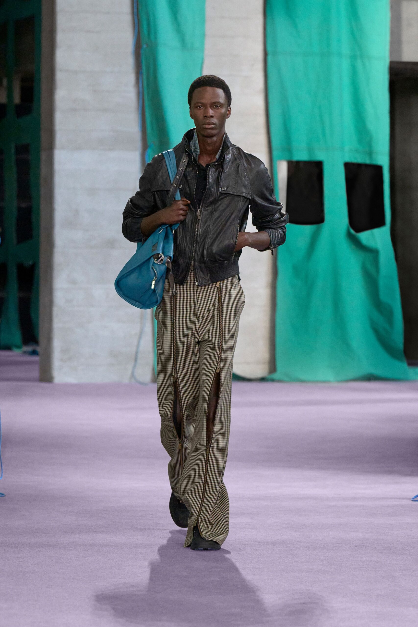 black leather jacket beige pants blue bag