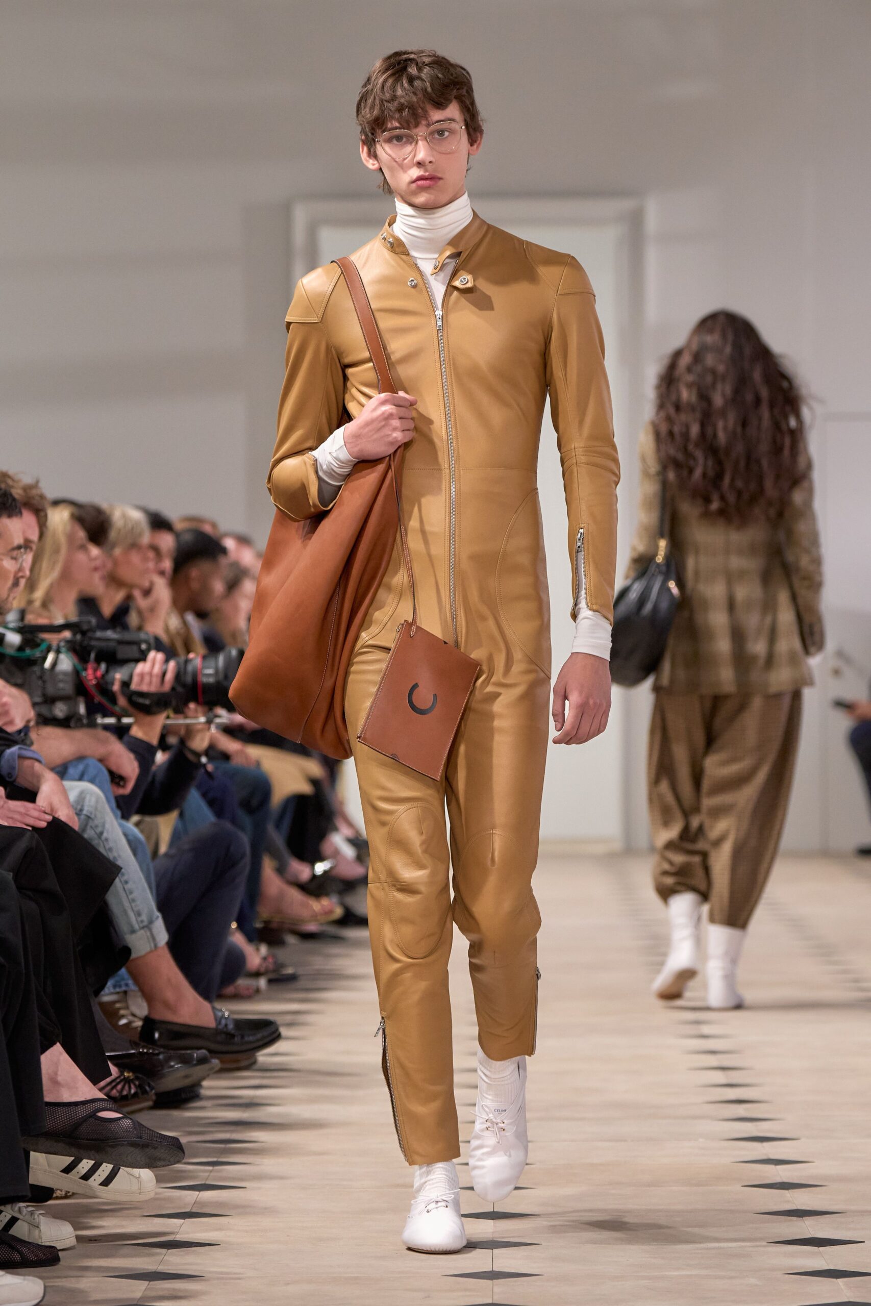 brown leather jumpsuit with white shoes