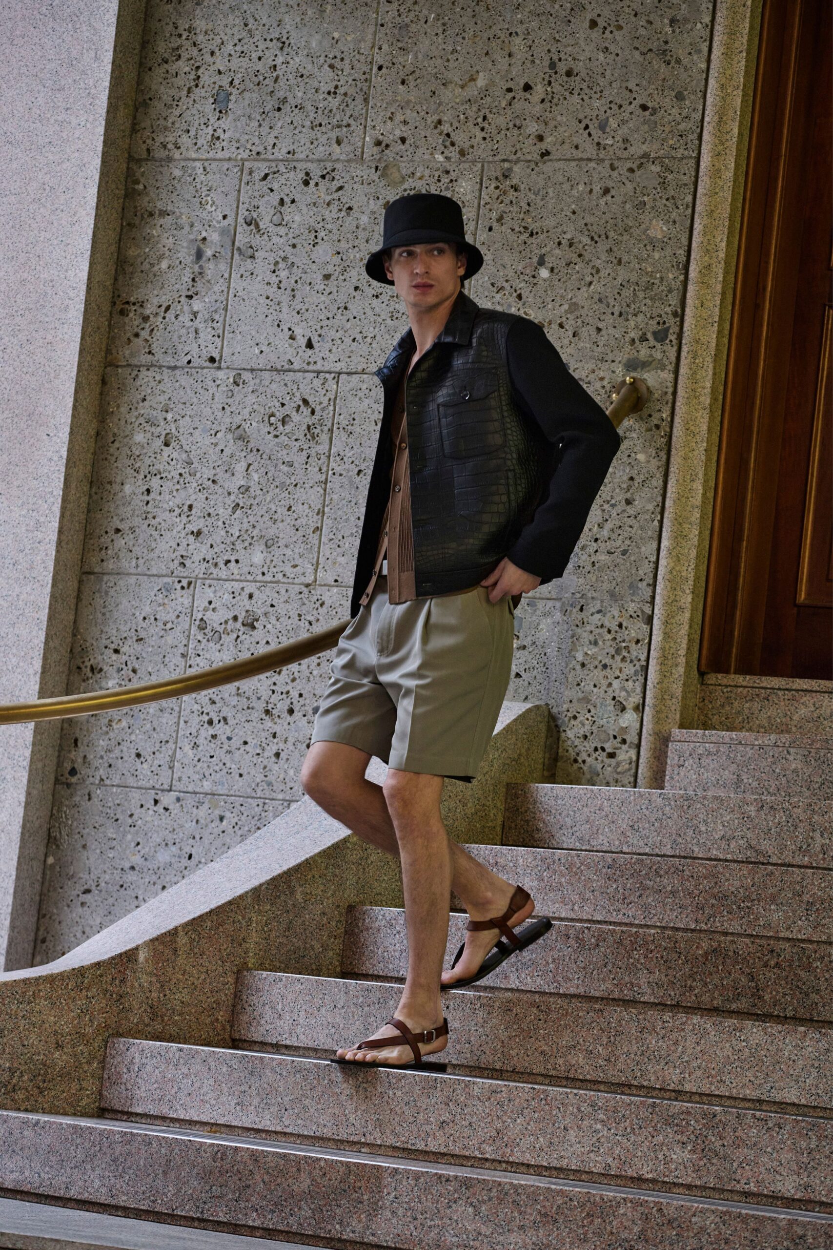 black leather jacket with beige shorts