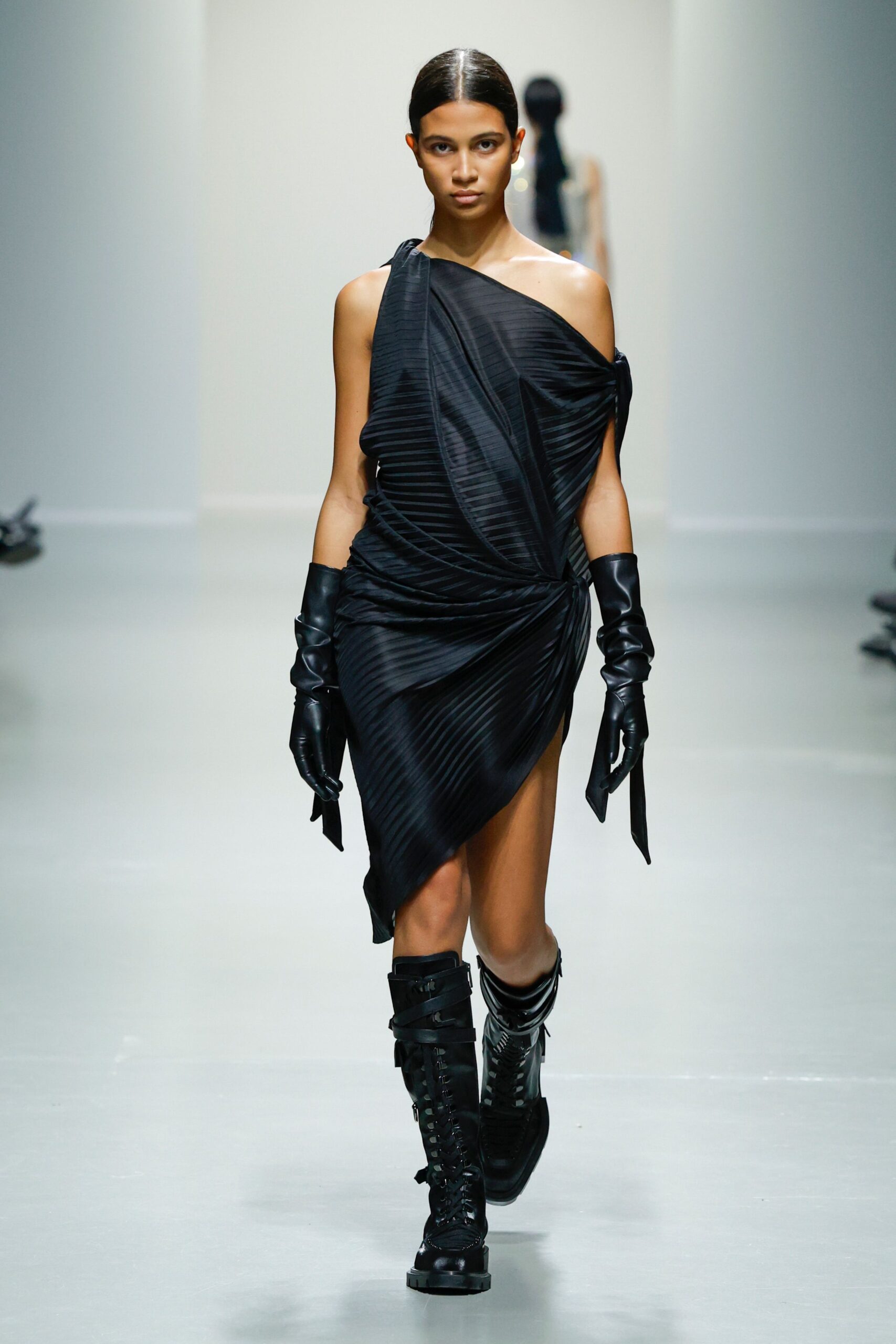 black fitted asymmetric dress with gloves and boots