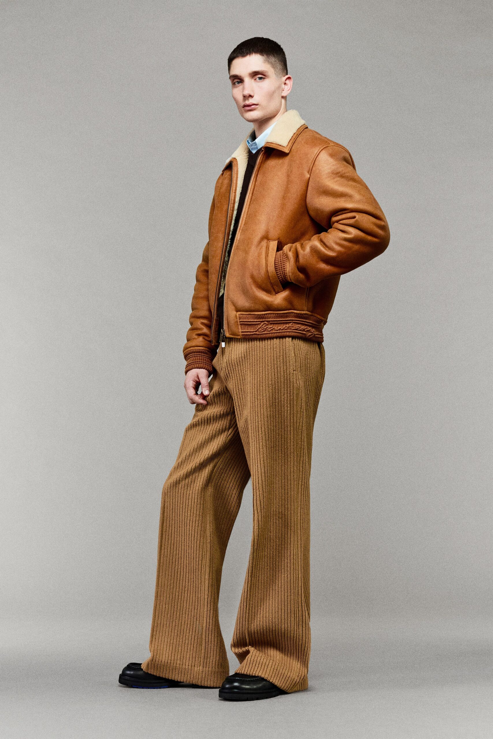 brown leather jacket and beige pants
