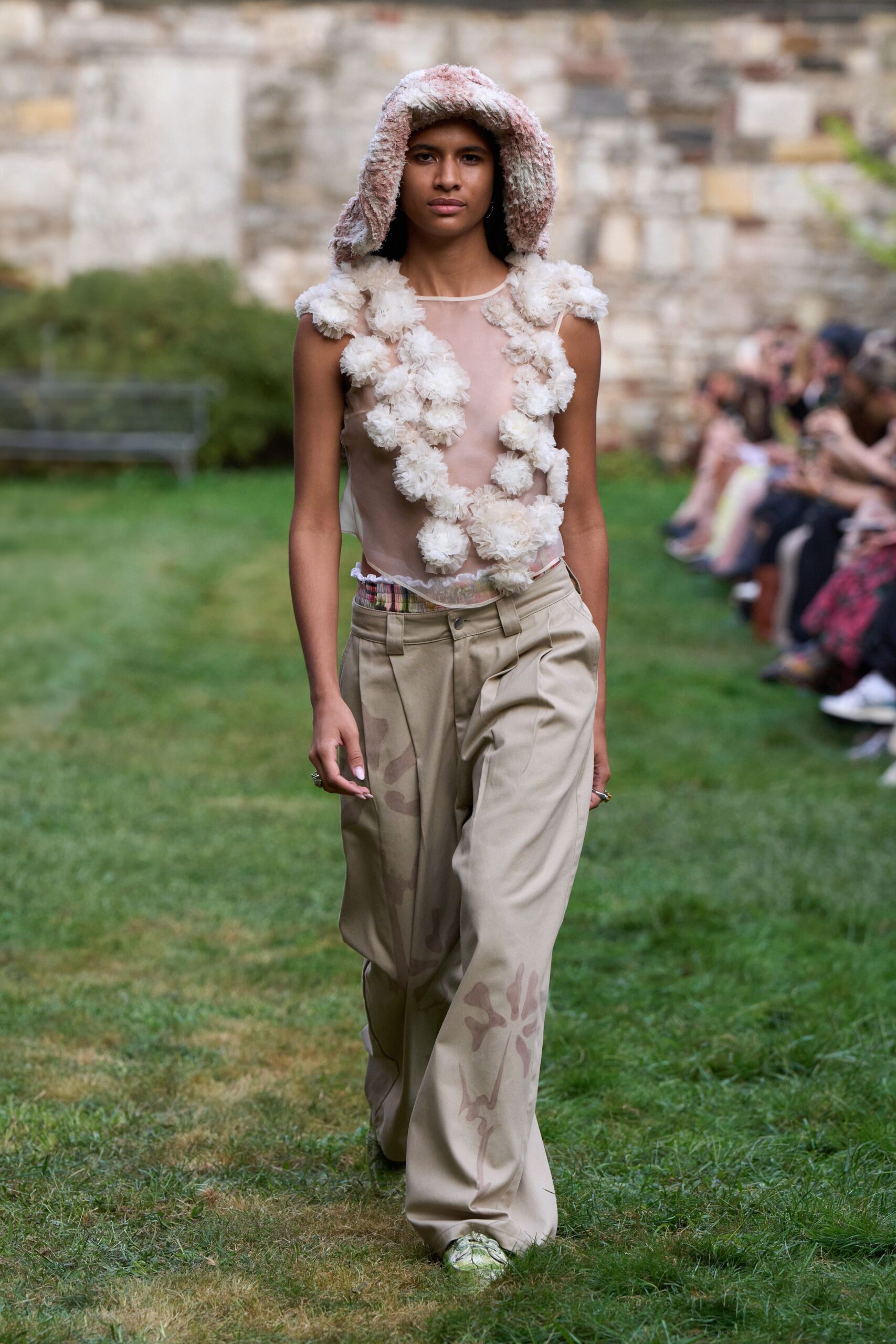 pink ruffled top with beige pants