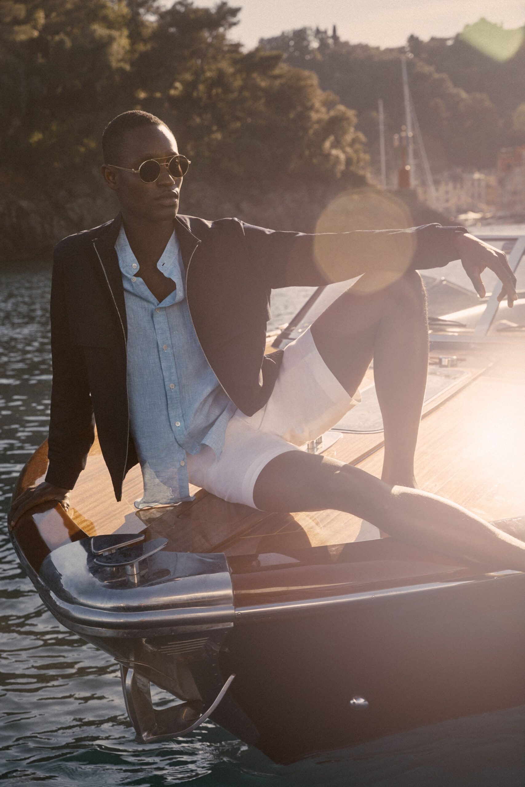 black jacket with light blue shirt and white shorts