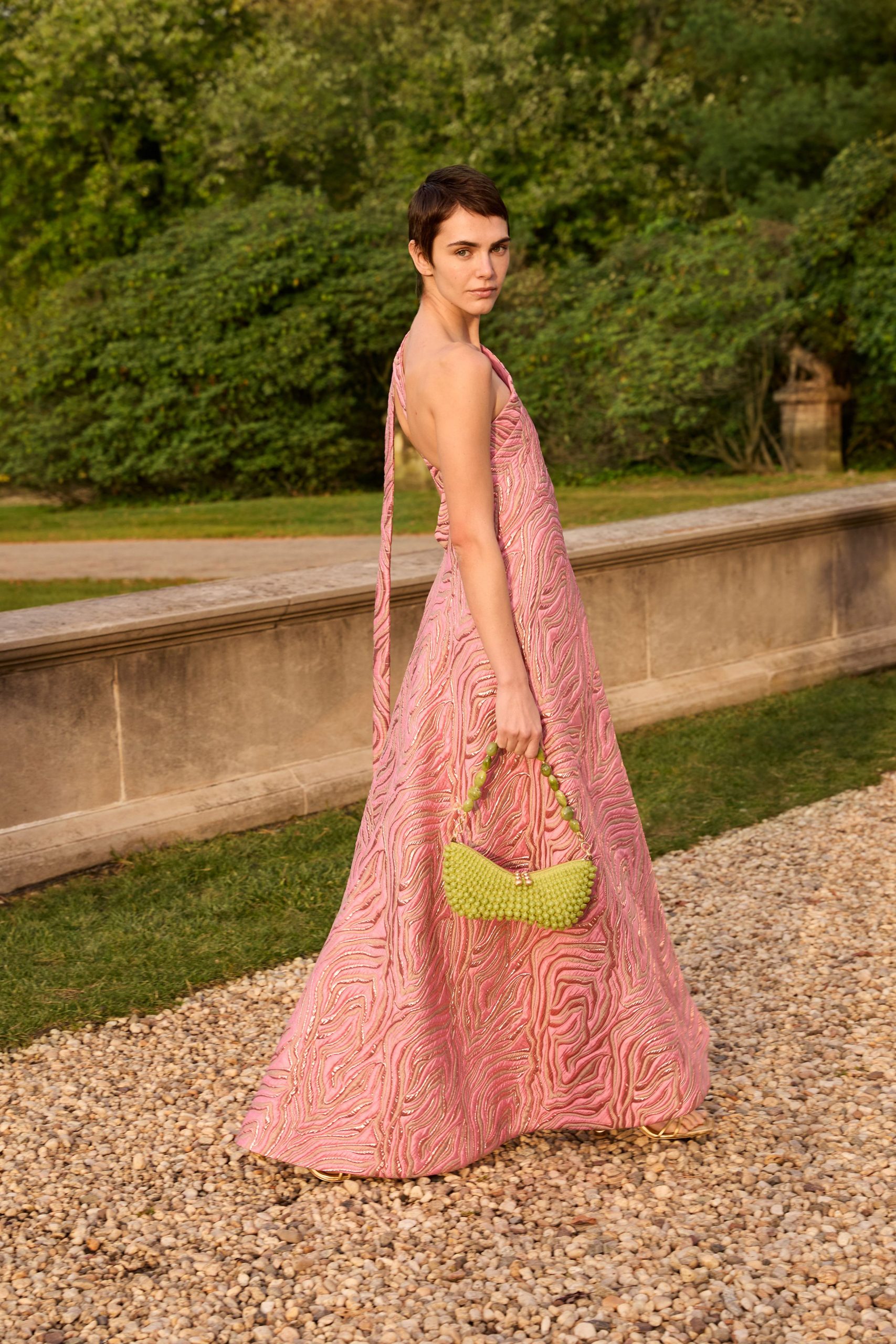 pink silk flared gown with green bag