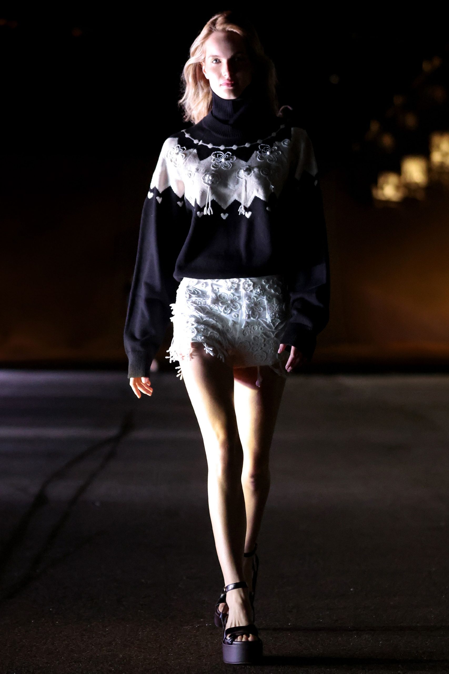 black oversized sweater with white fringed shorts