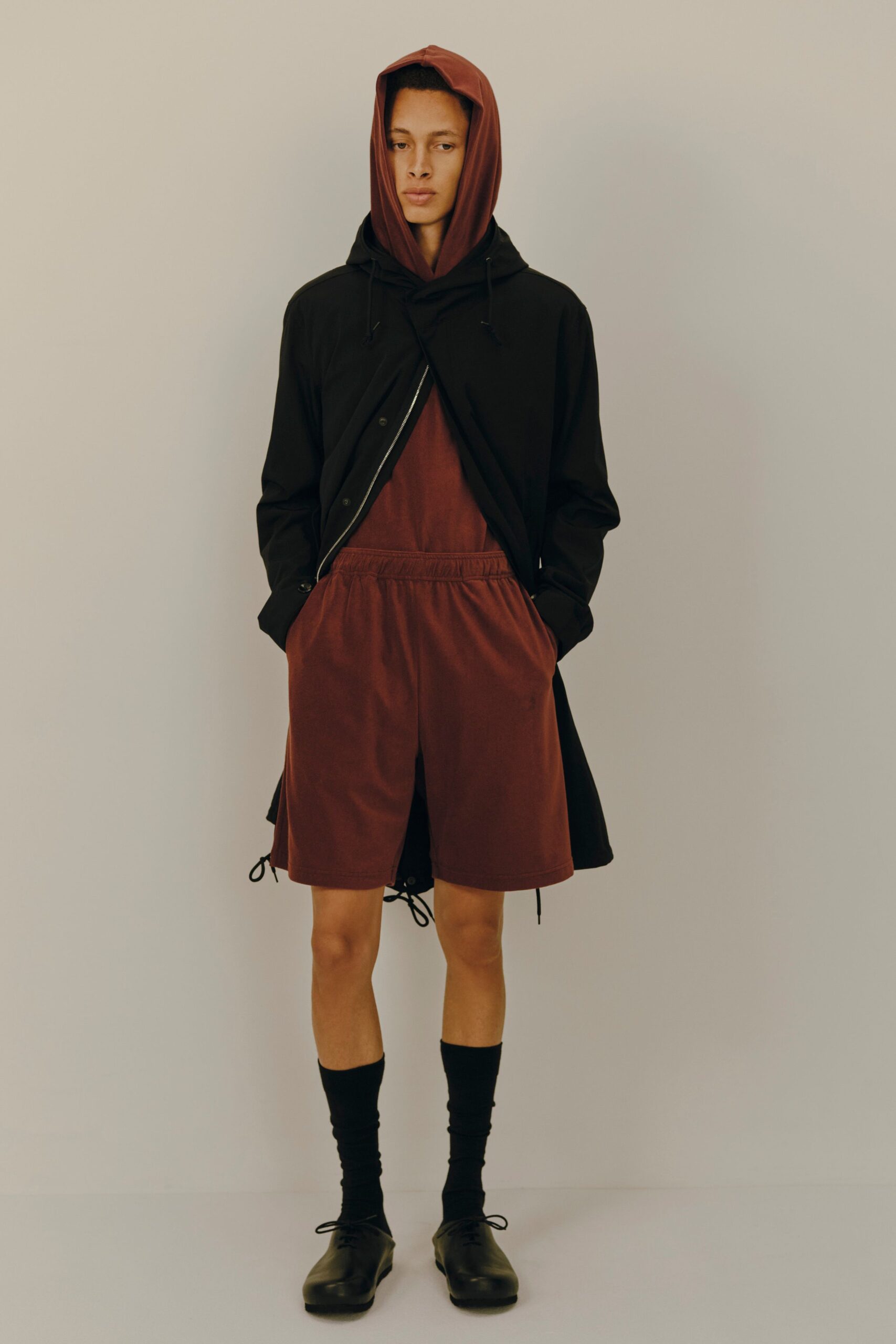 black coat red hoodie brown shorts