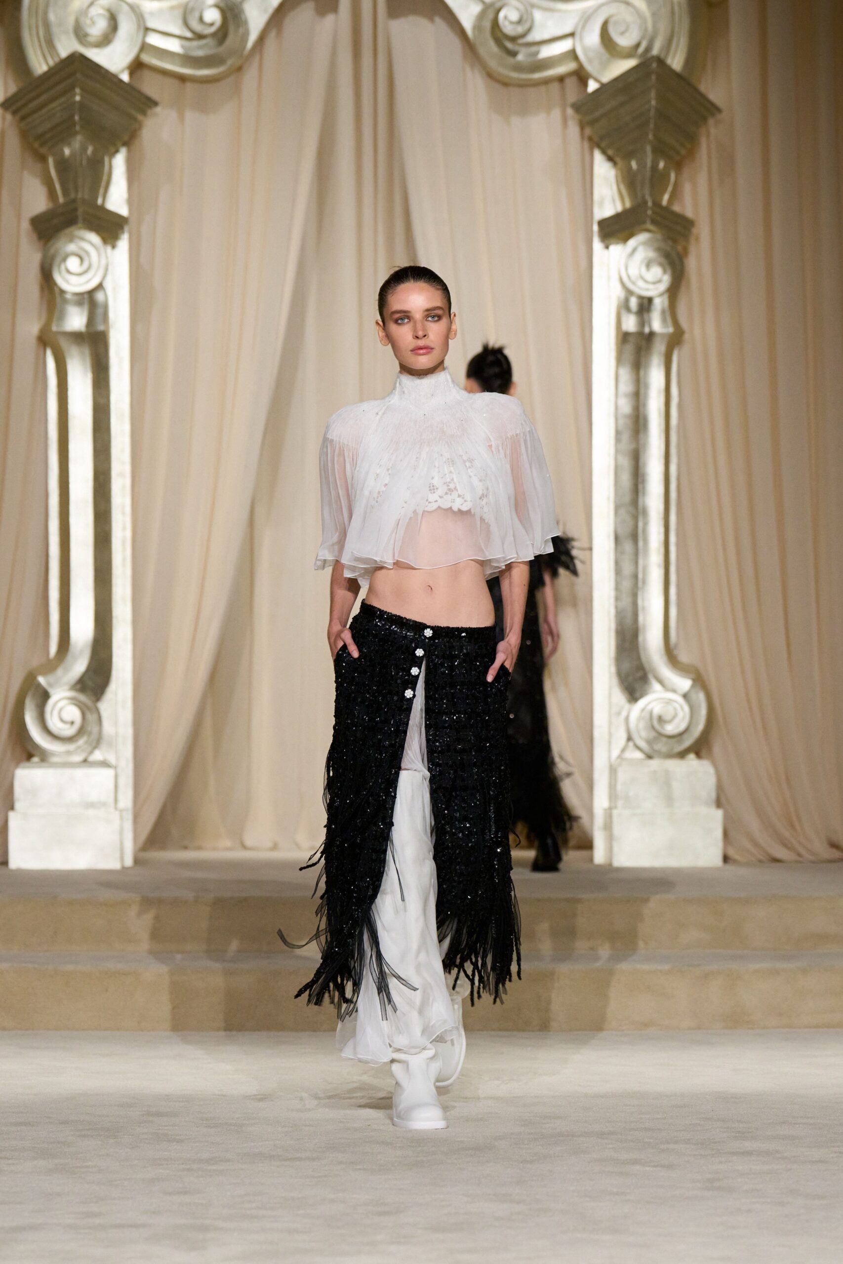 white silk ruffled top and black fringed skirt