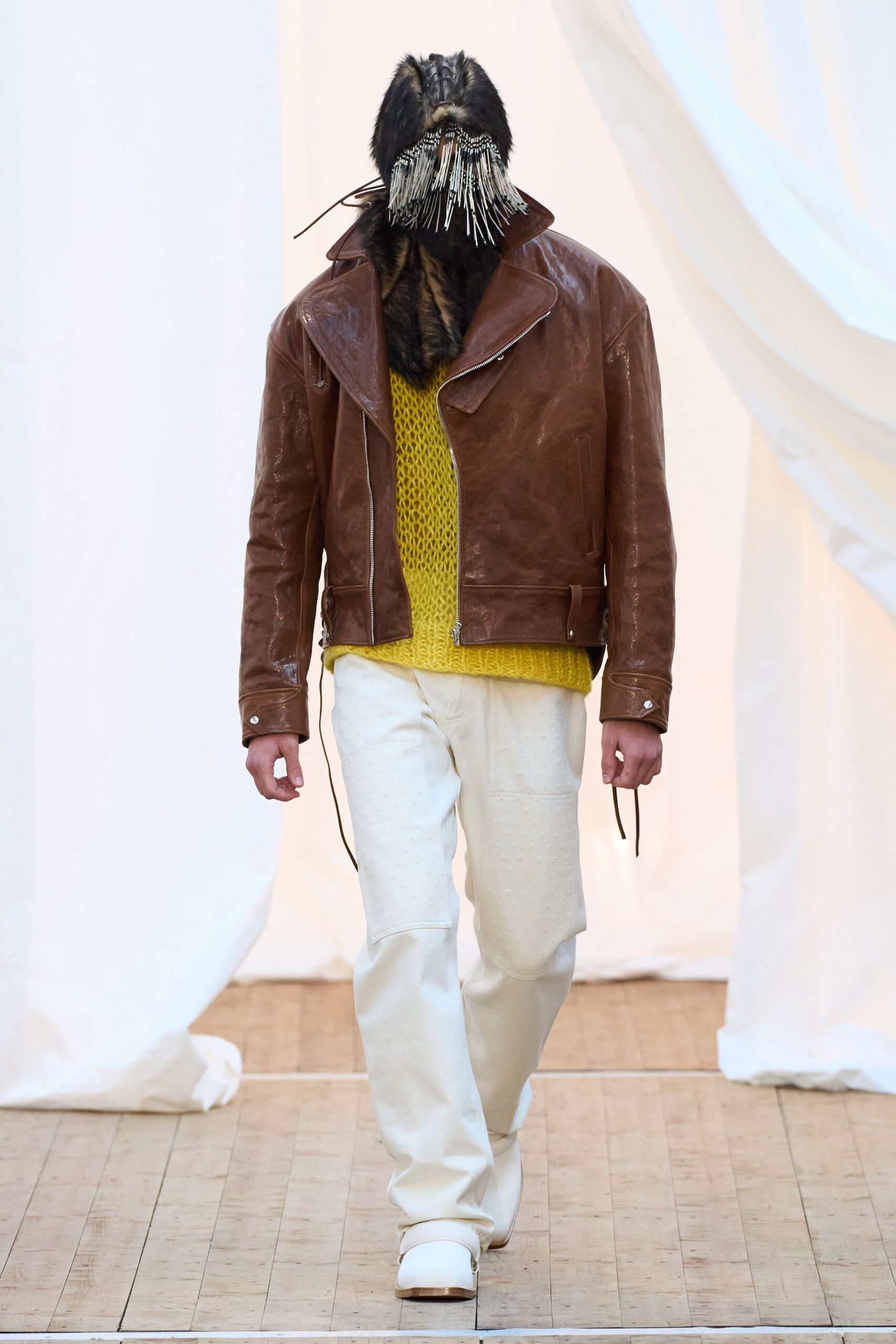 brown leather jacket yellow sweater white pants