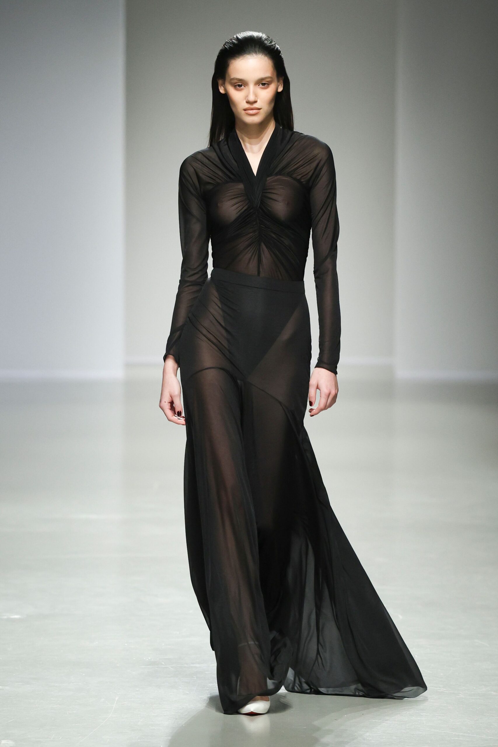 black sheer long-sleeve gown with white shoes