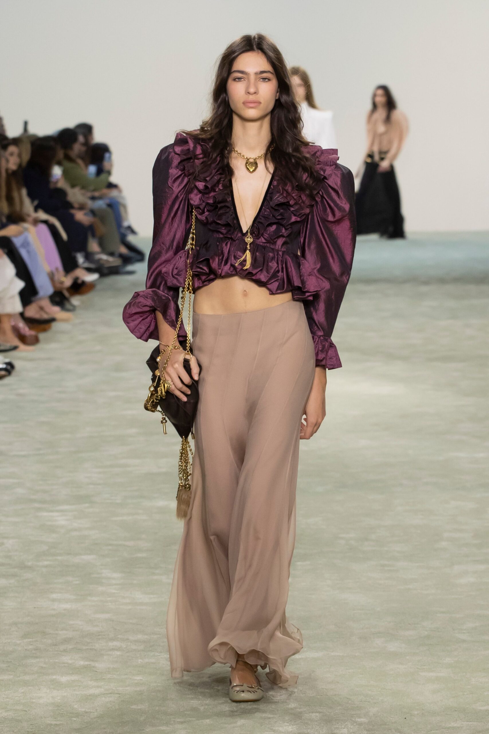 purple ruffled top with beige skirt