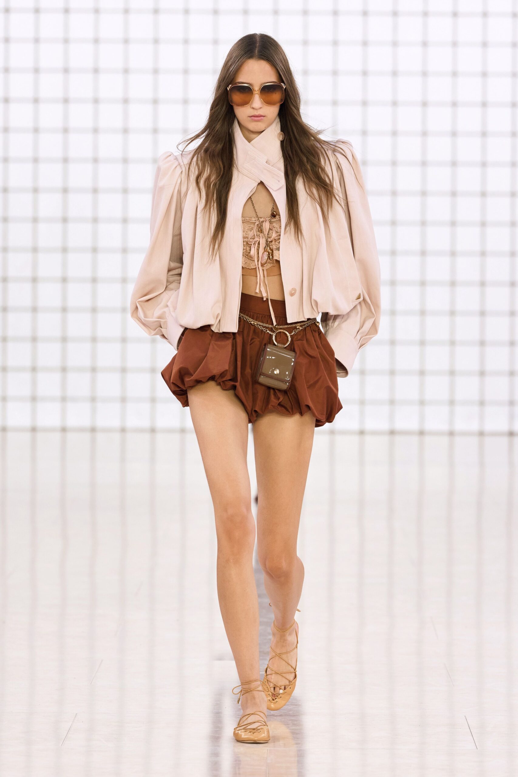 beige jacket pink top brown shorts