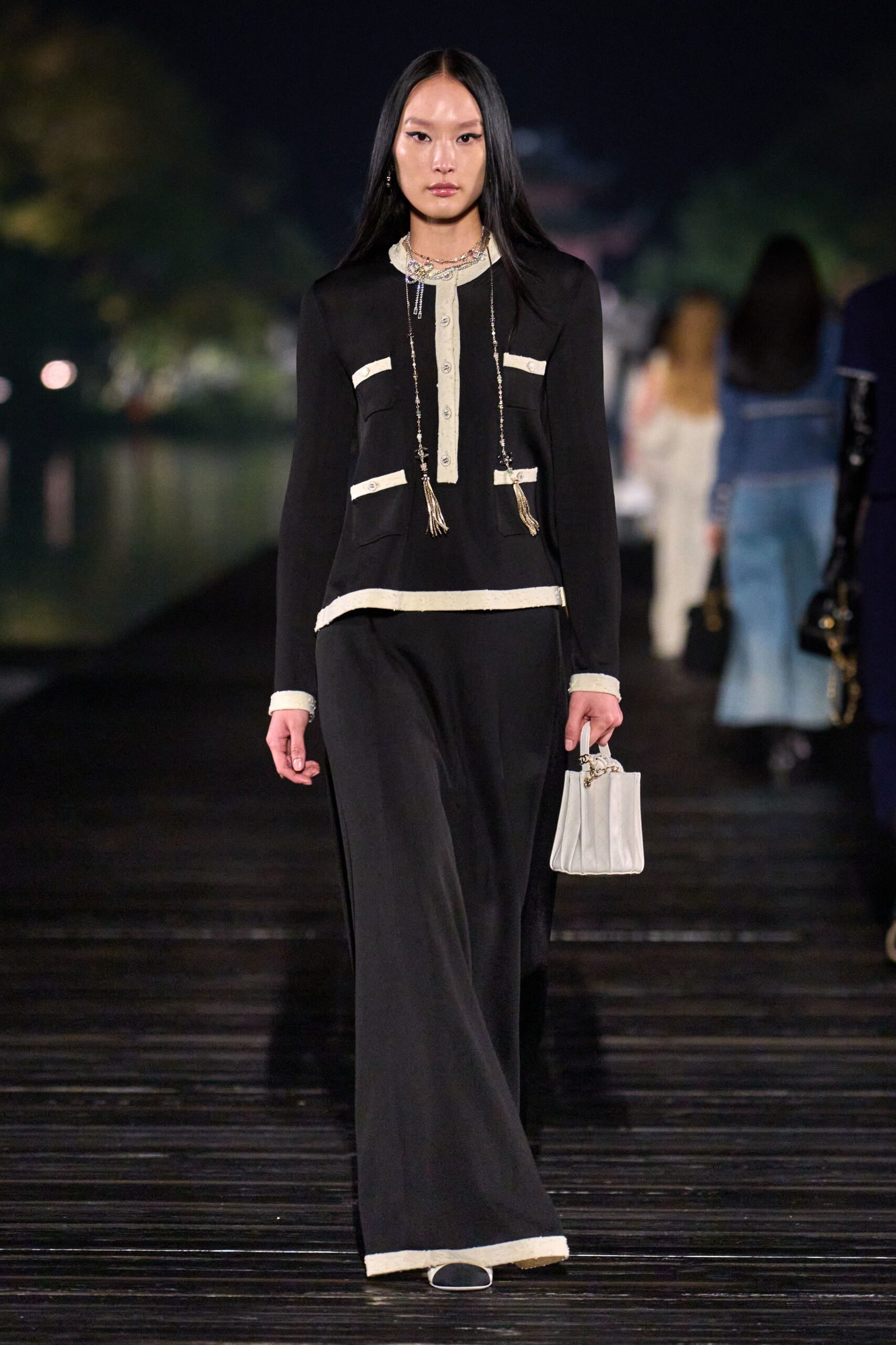 black fitted jumpsuit with white bag
