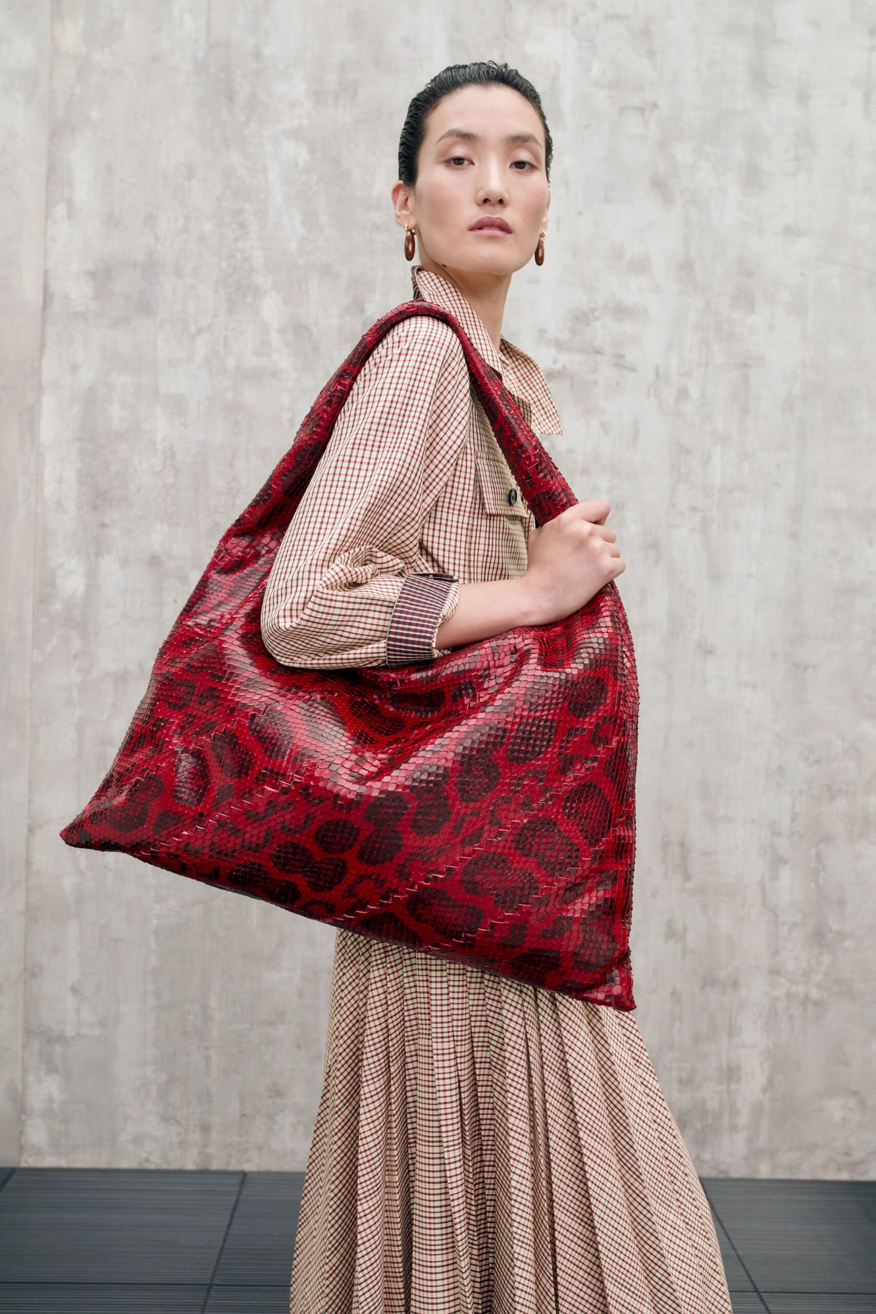 beige pleated midi dress with red bag