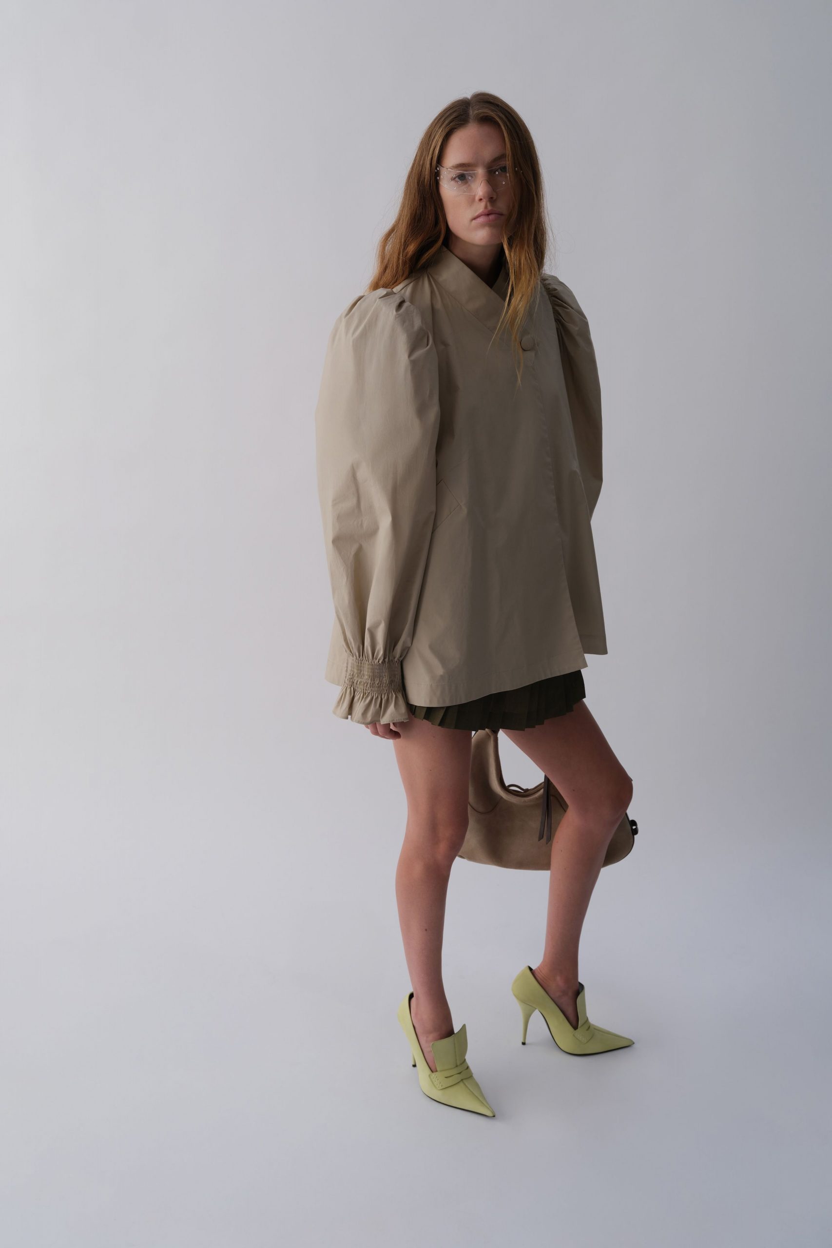 beige relaxed top with black pleated skirt