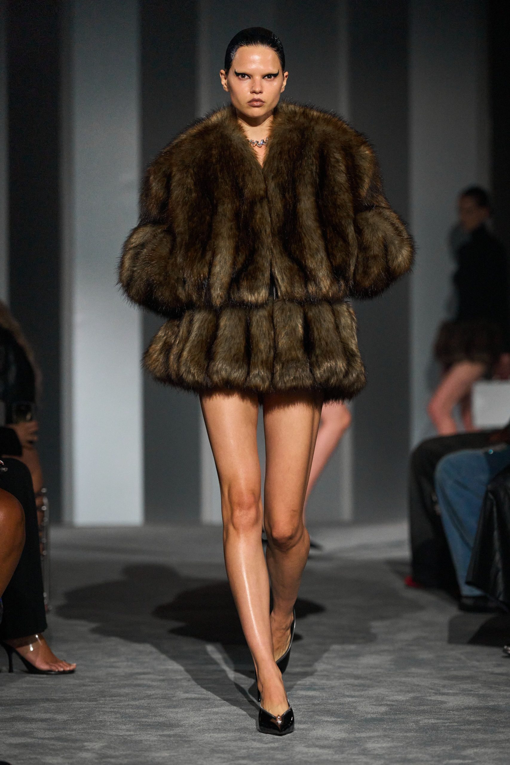 brown fur oversized coat with black leather shorts