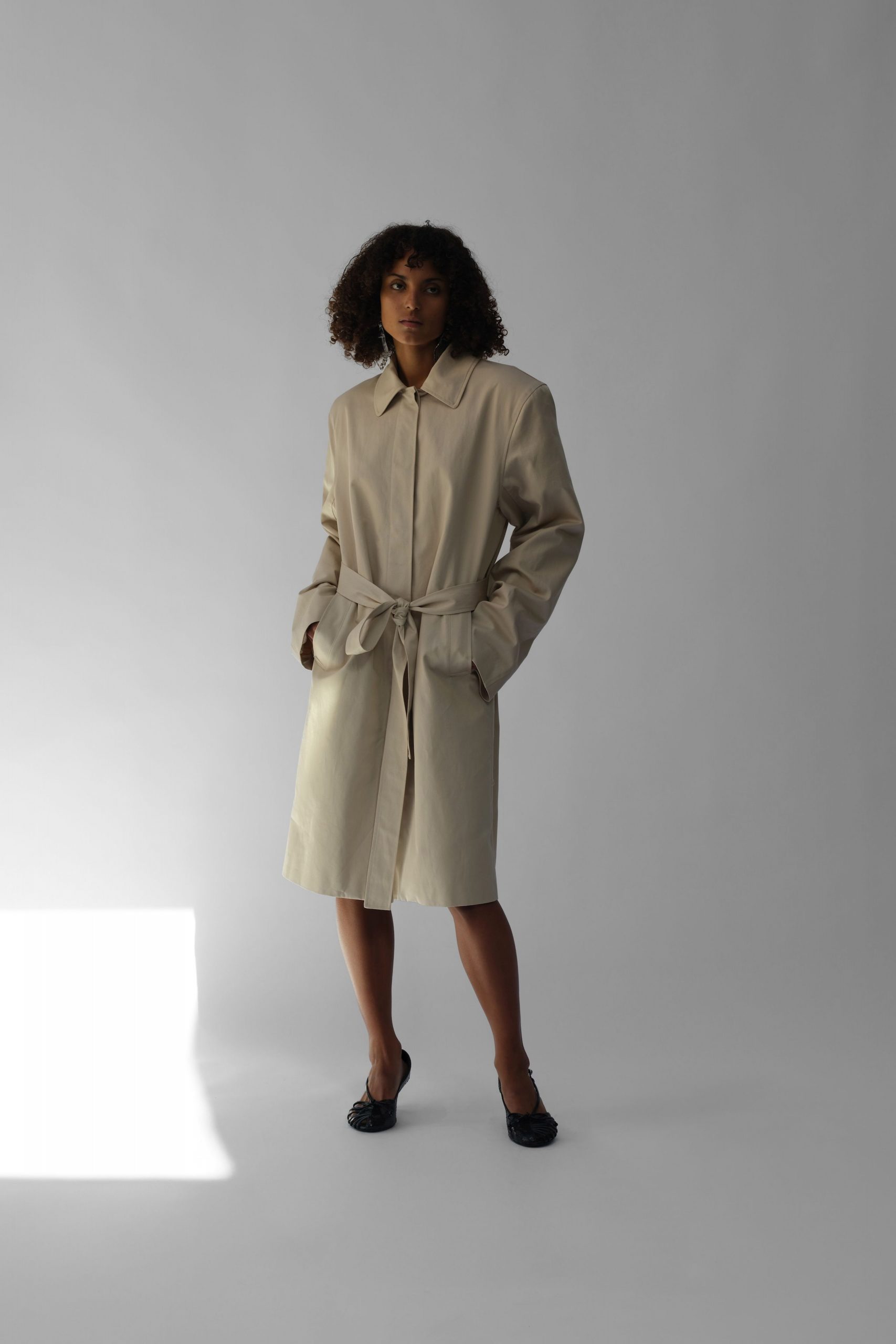 beige leather belted coat with black shoes