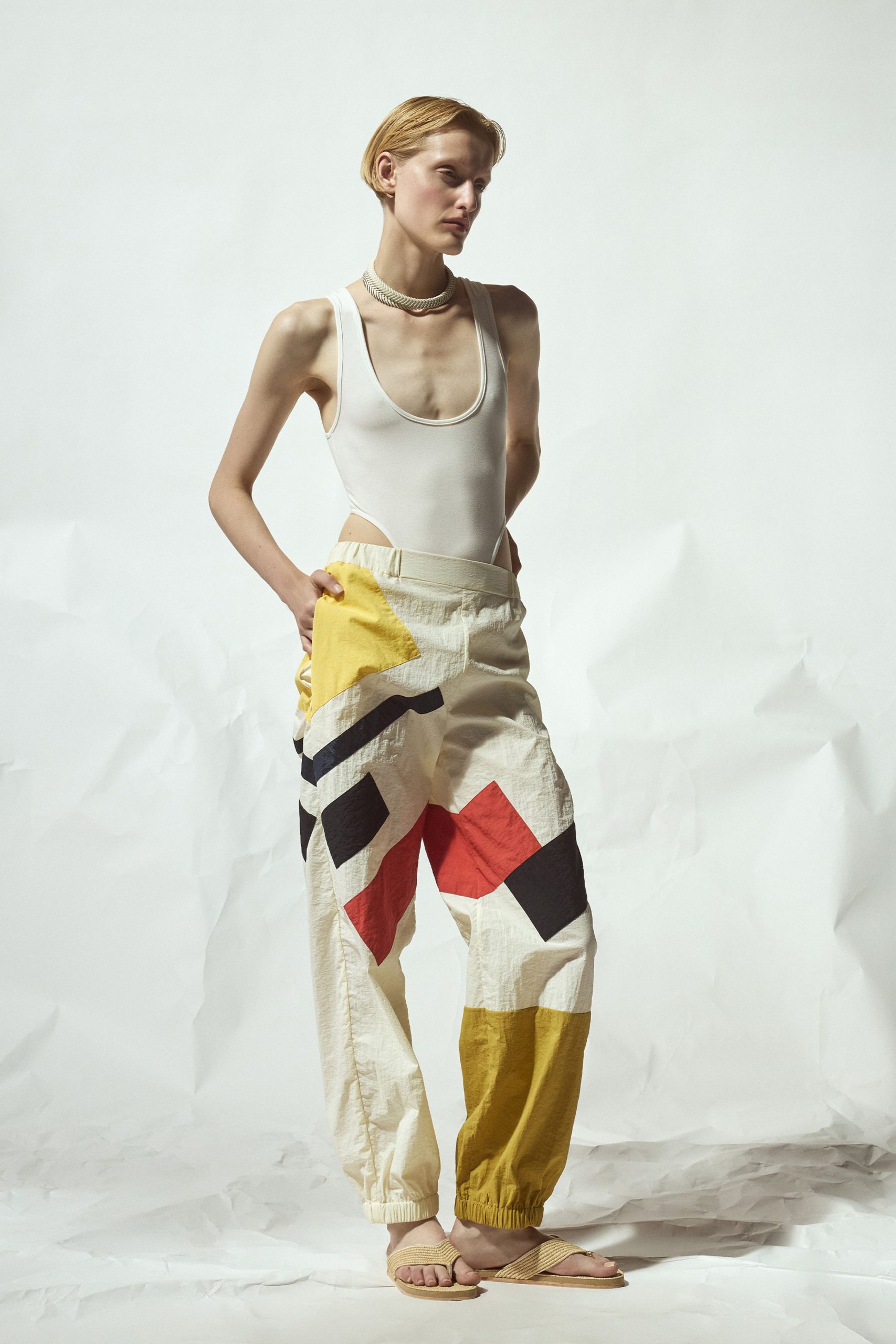 white bodysuit with color-blocked pants