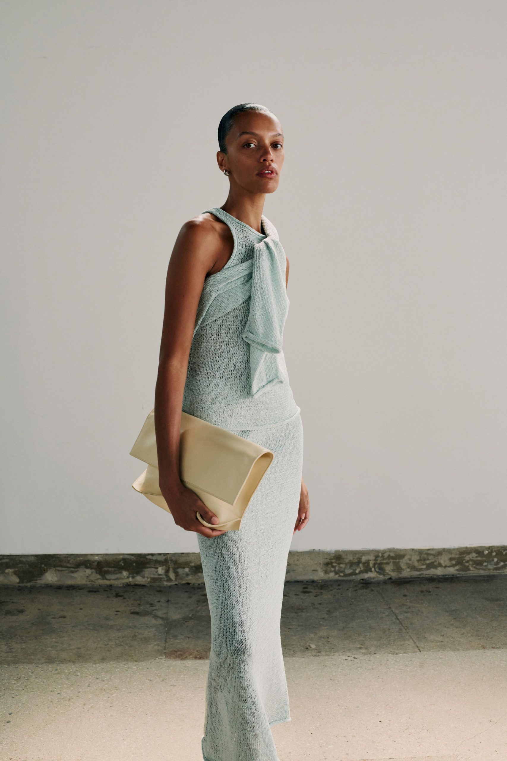 fitted blue cotton midi dress with beige bag