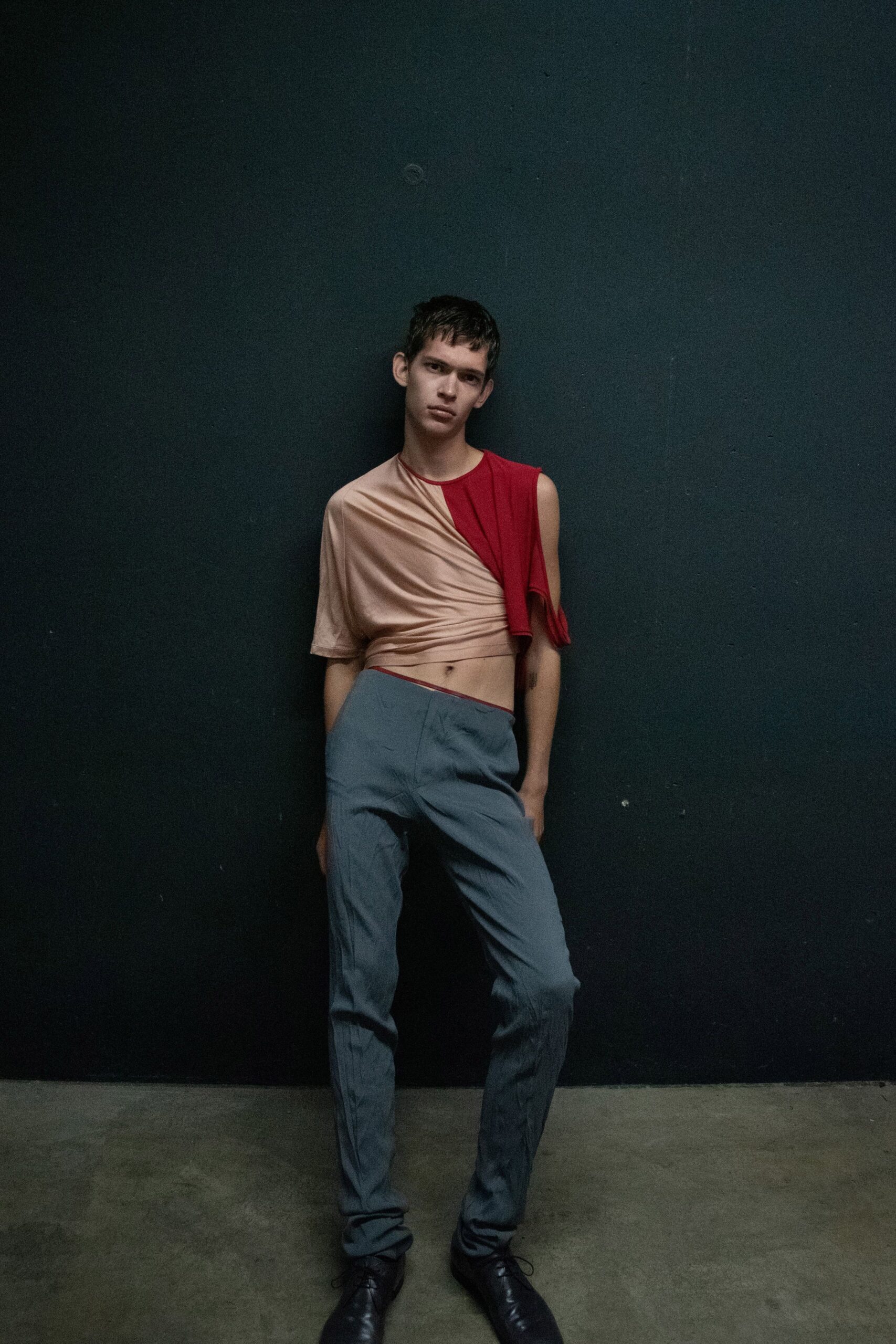 asymmetric beige and red top with gray pants