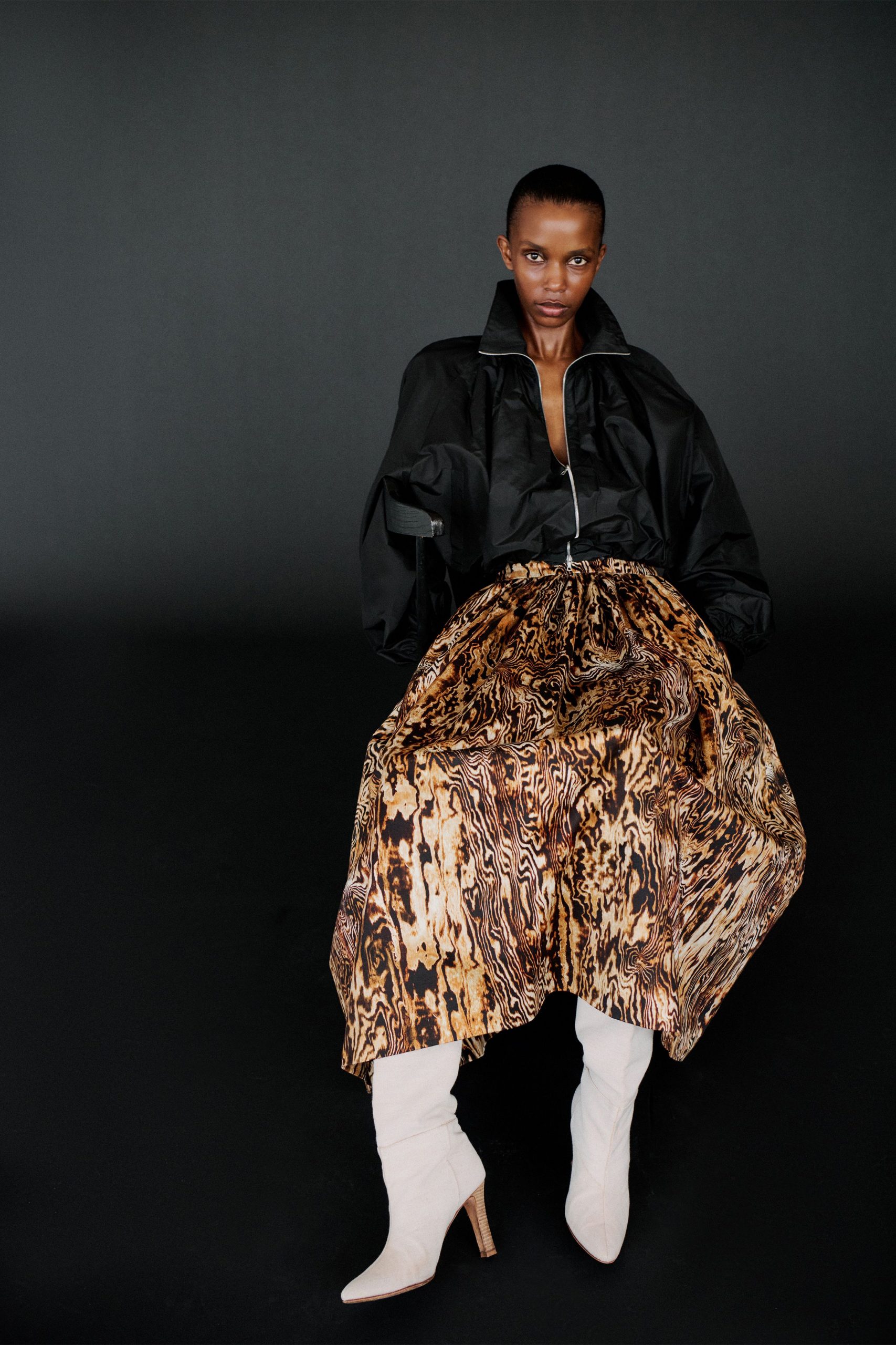 black jacket brown pleated skirt white boots