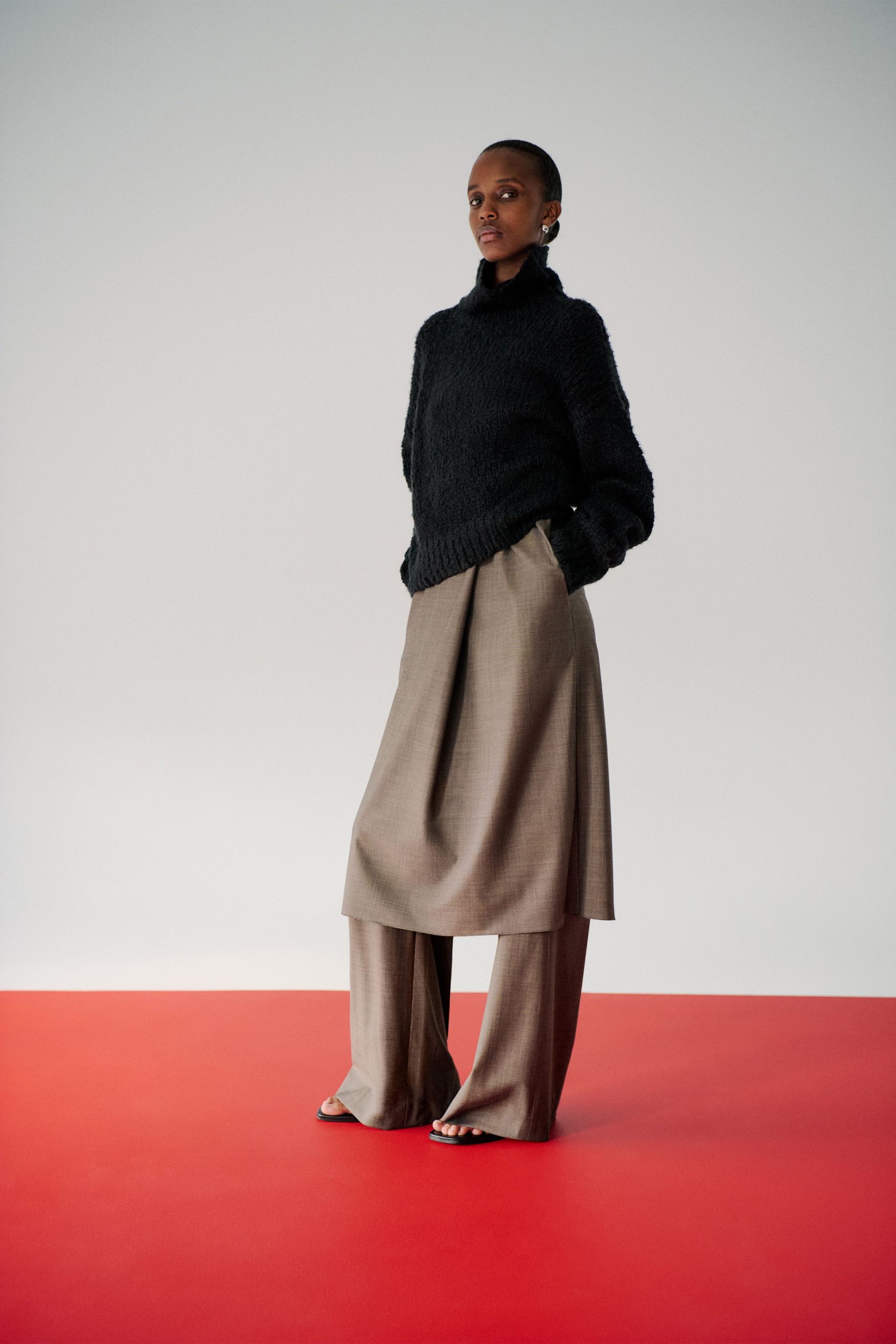 black wool relaxed sweater with beige pants