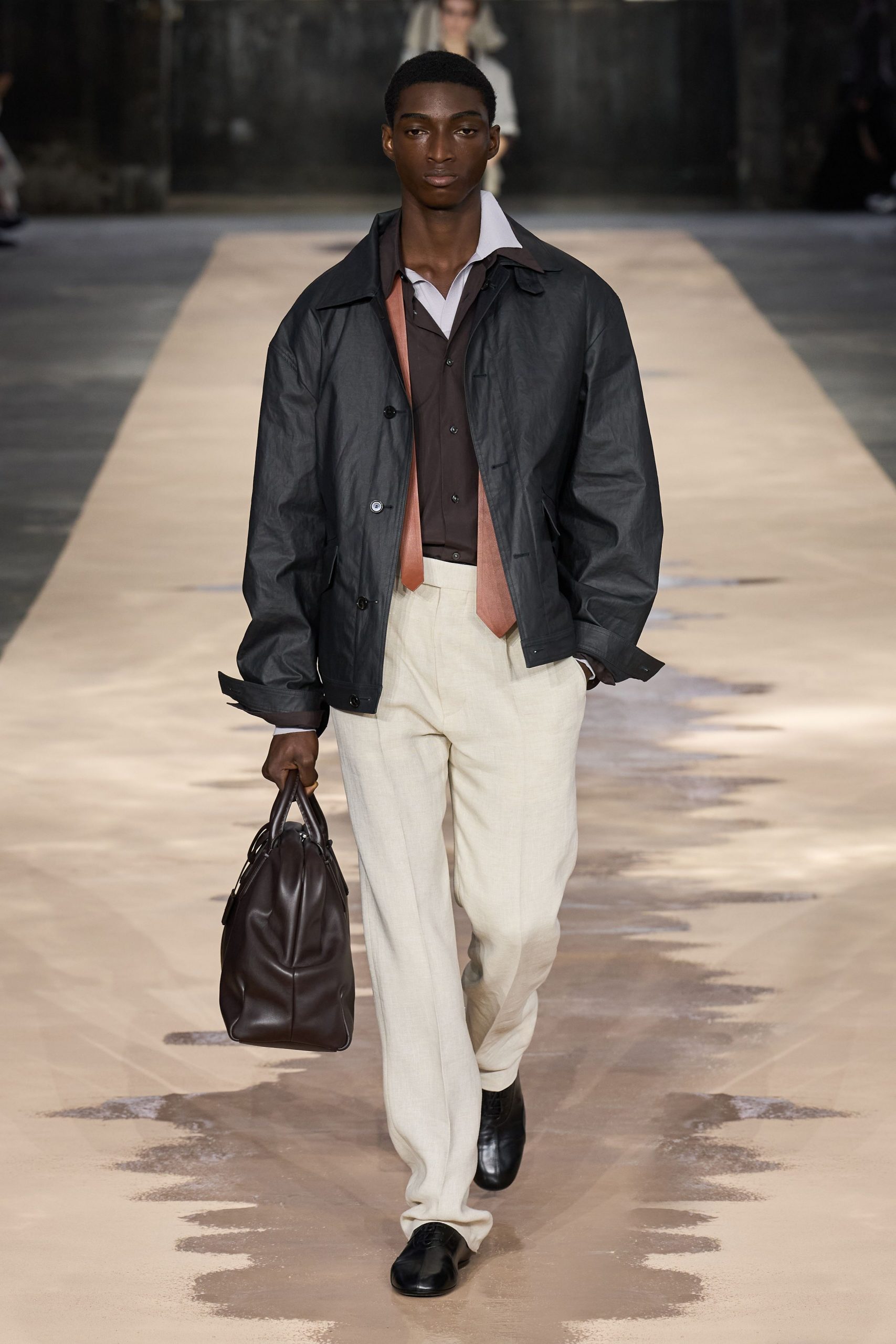 black jacket brown shirt beige pants