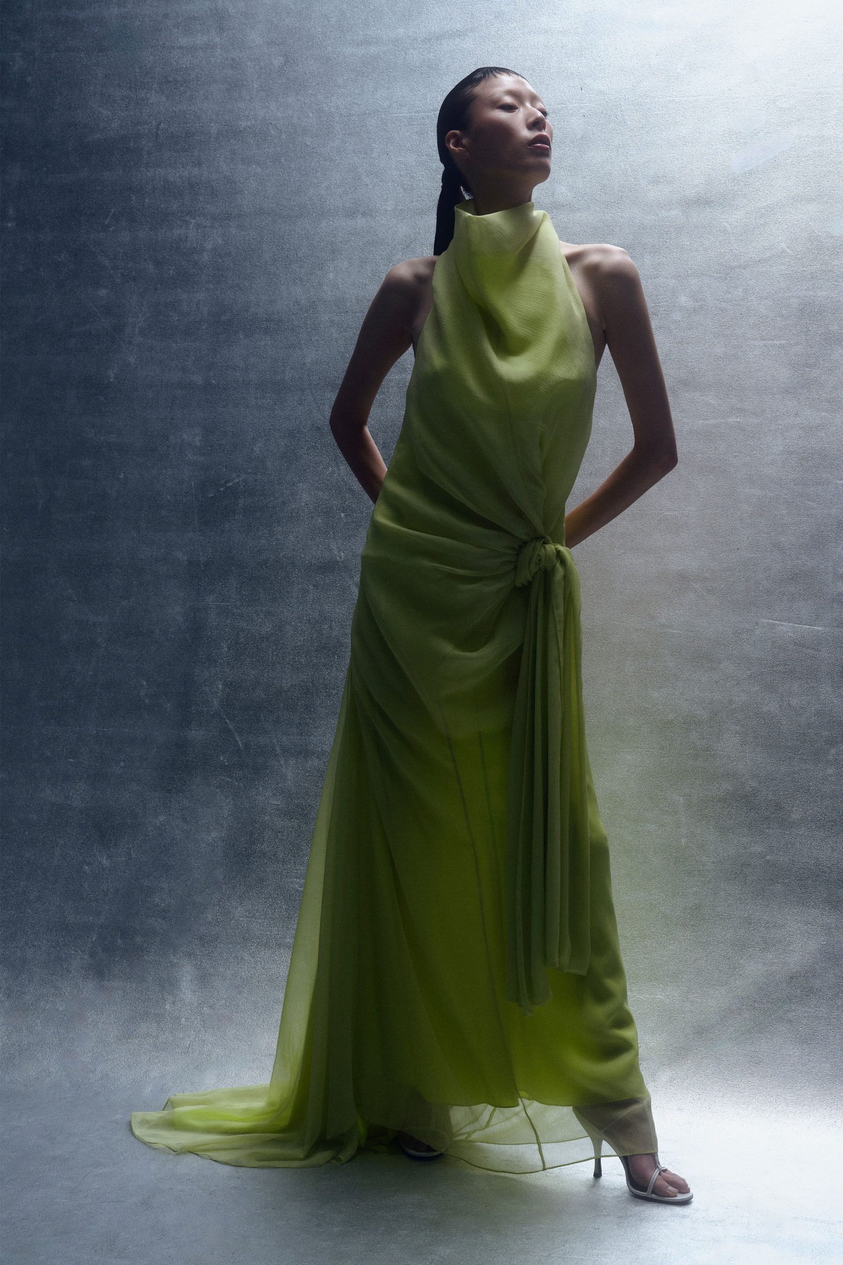 green silk sleeveless high-neck fitted draped flowing gown