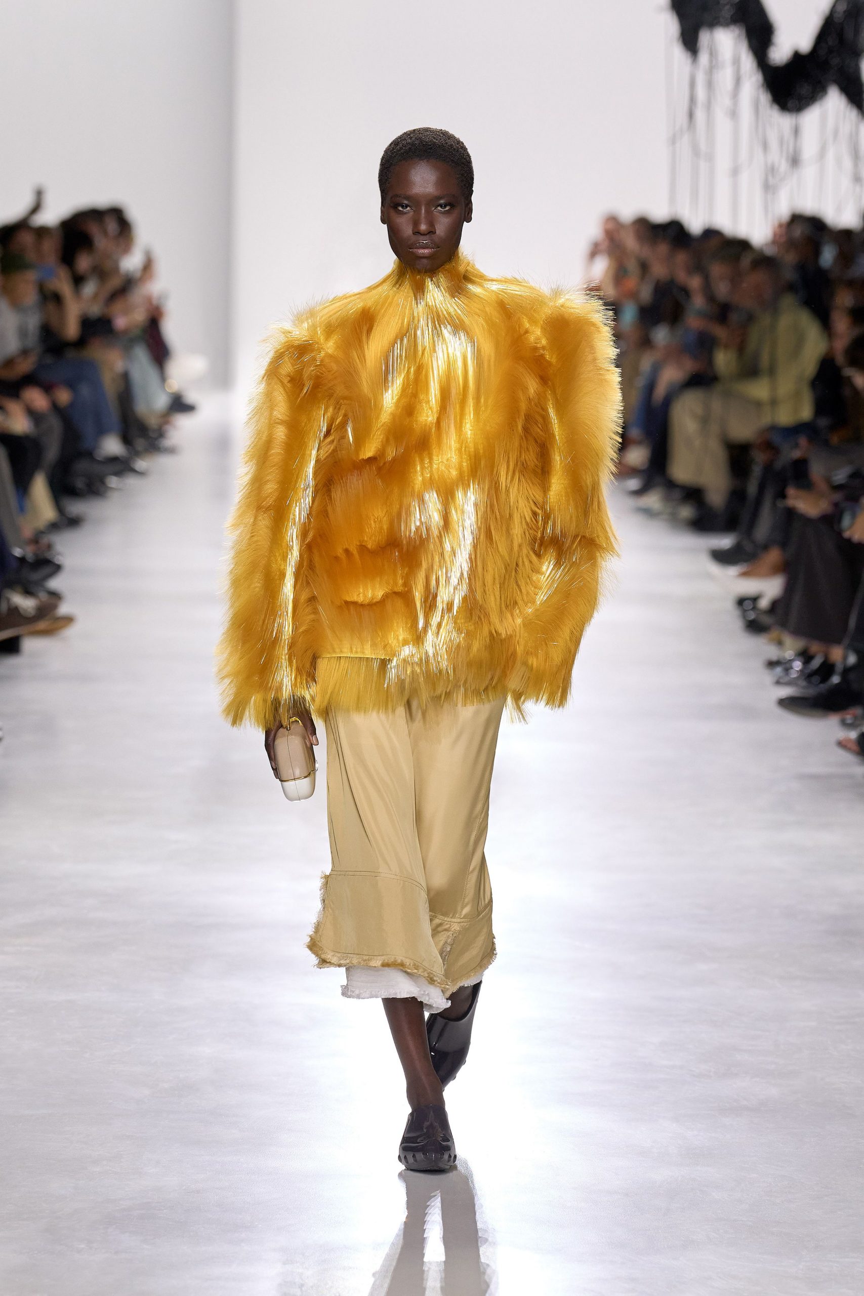 yellow fringed top with beige pants