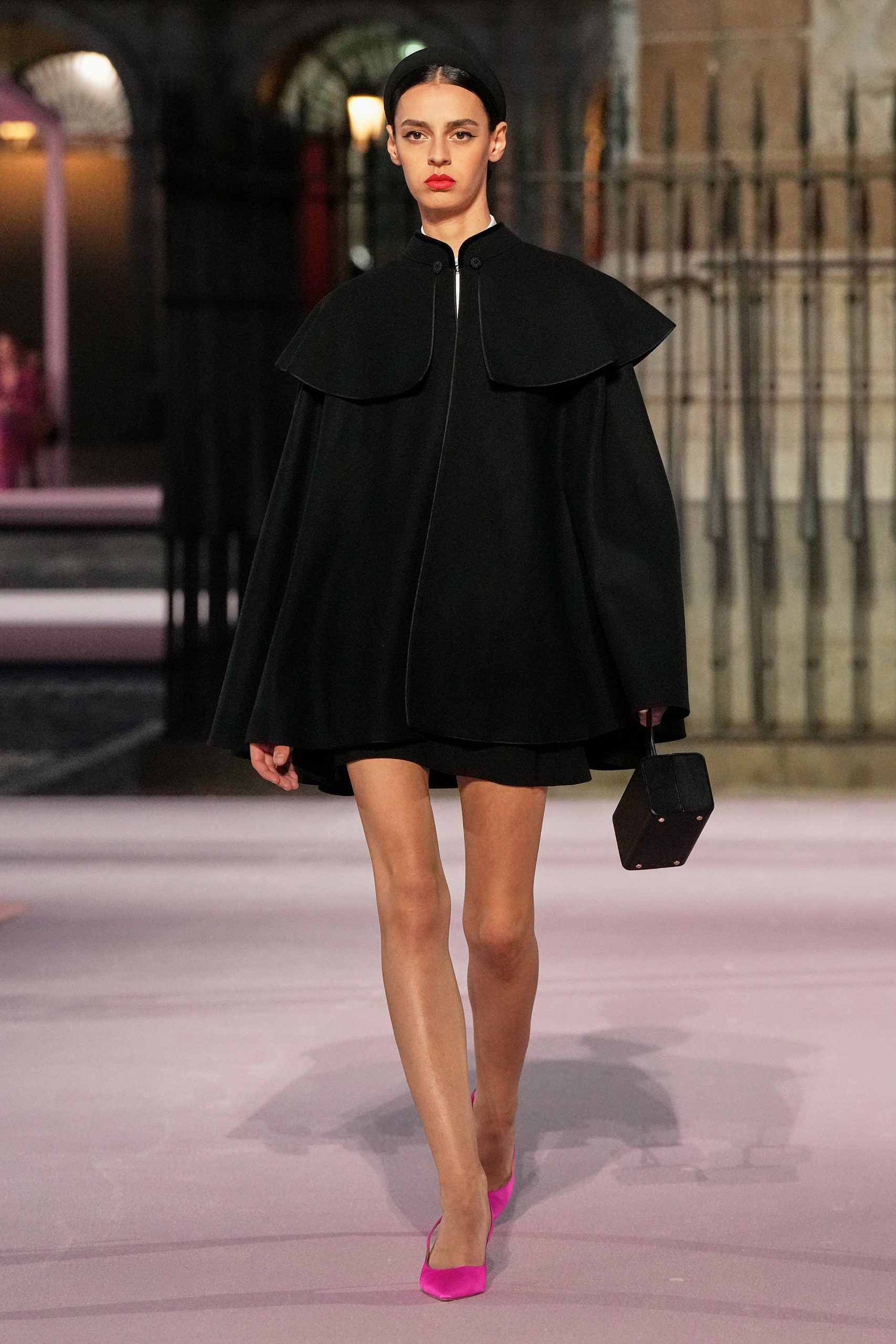 black cape mini dress with pink shoes