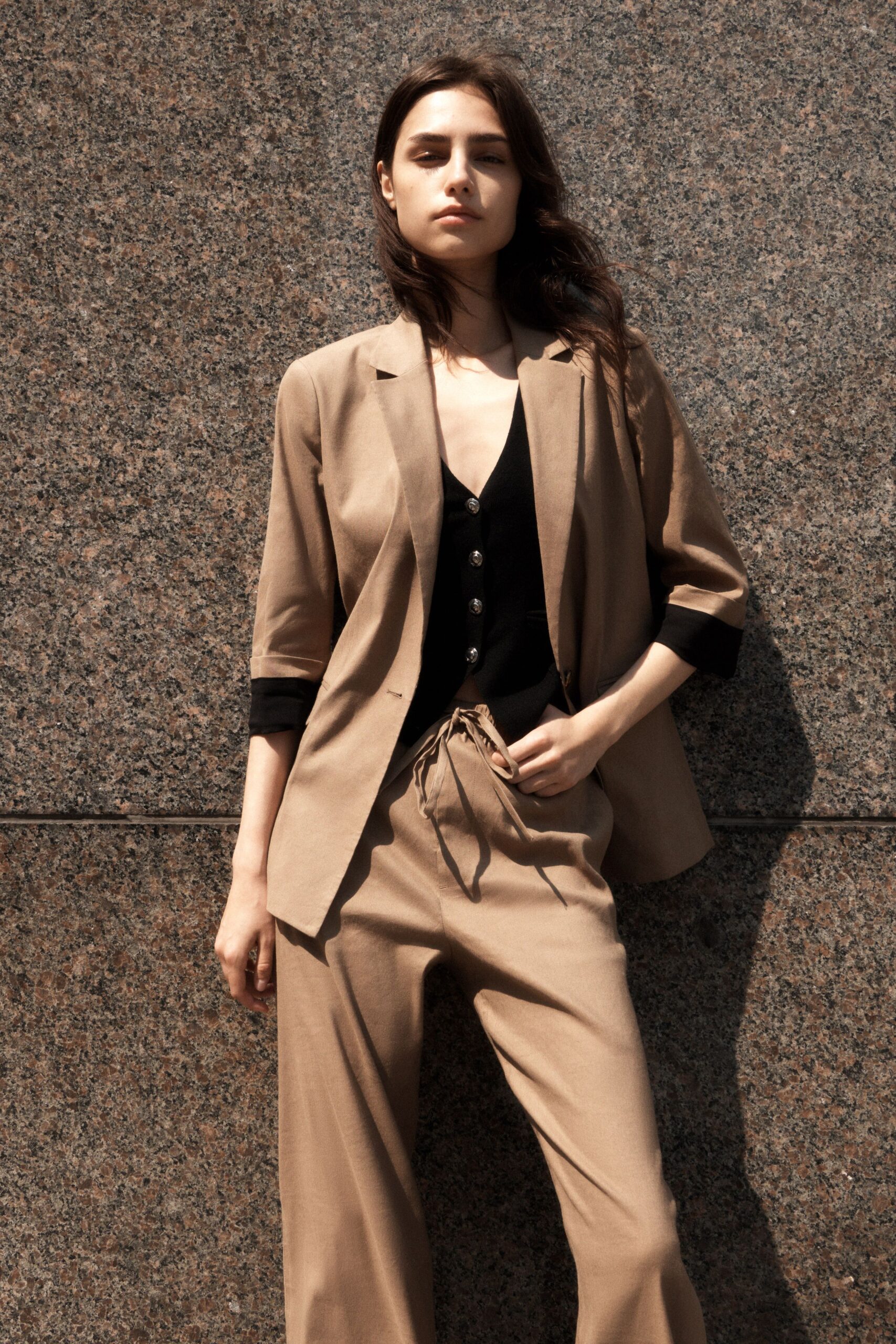 beige blazer black top beige pants