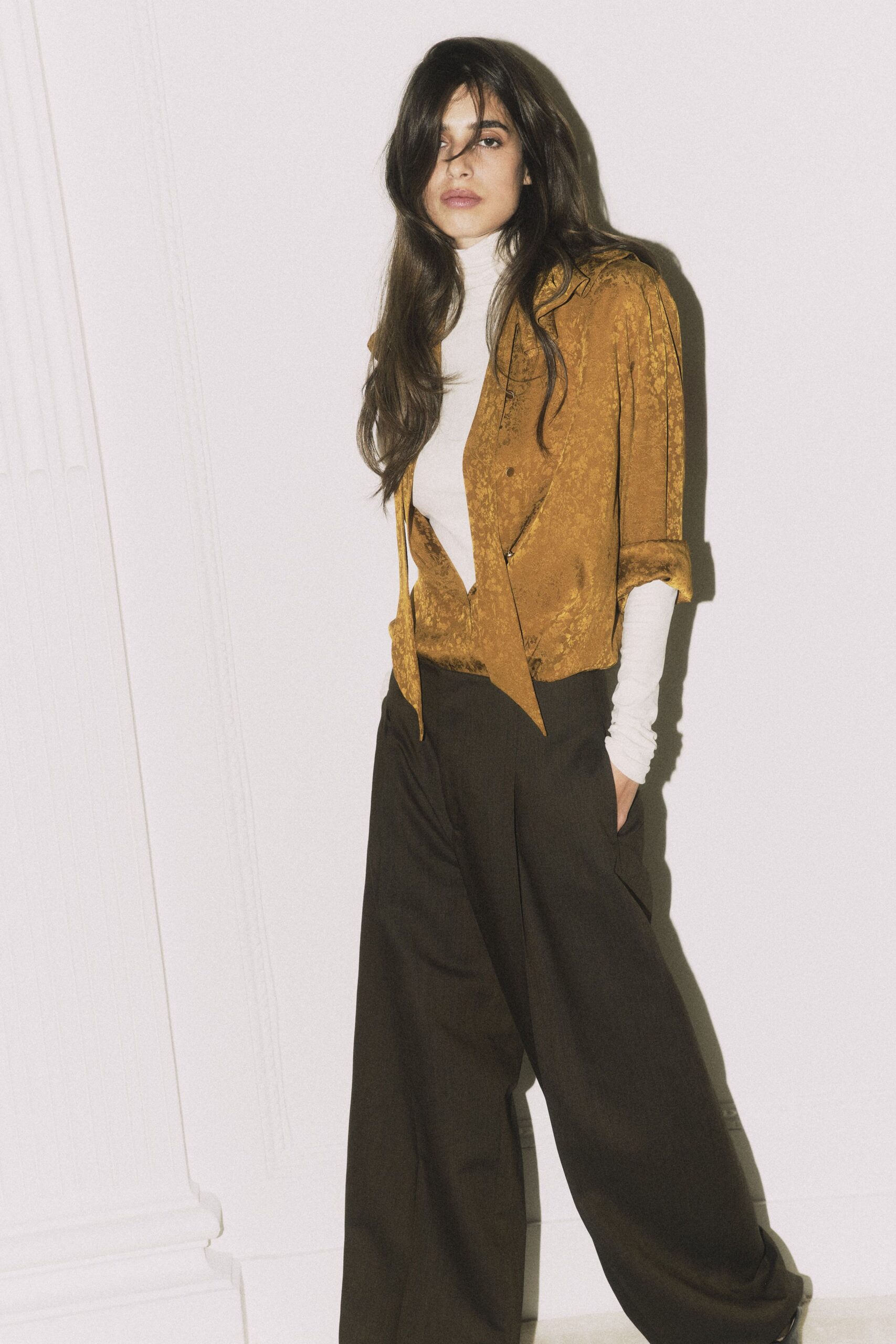 gold silk shirt with brown pants