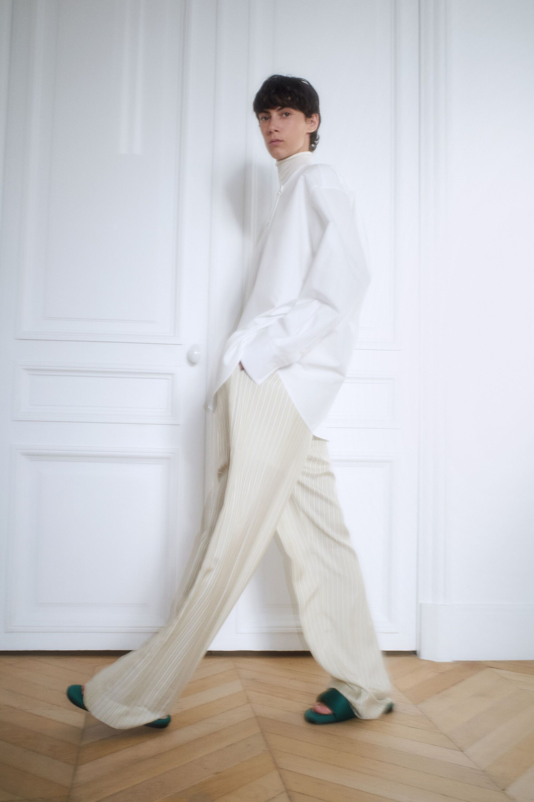 white relaxed shirt beige striped pants green sandals