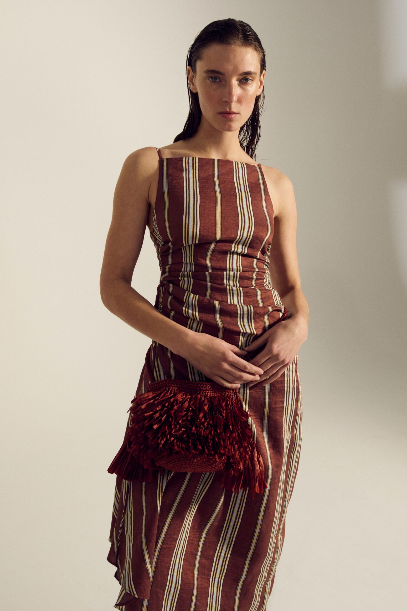 brown striped fitted midi dress with red bag