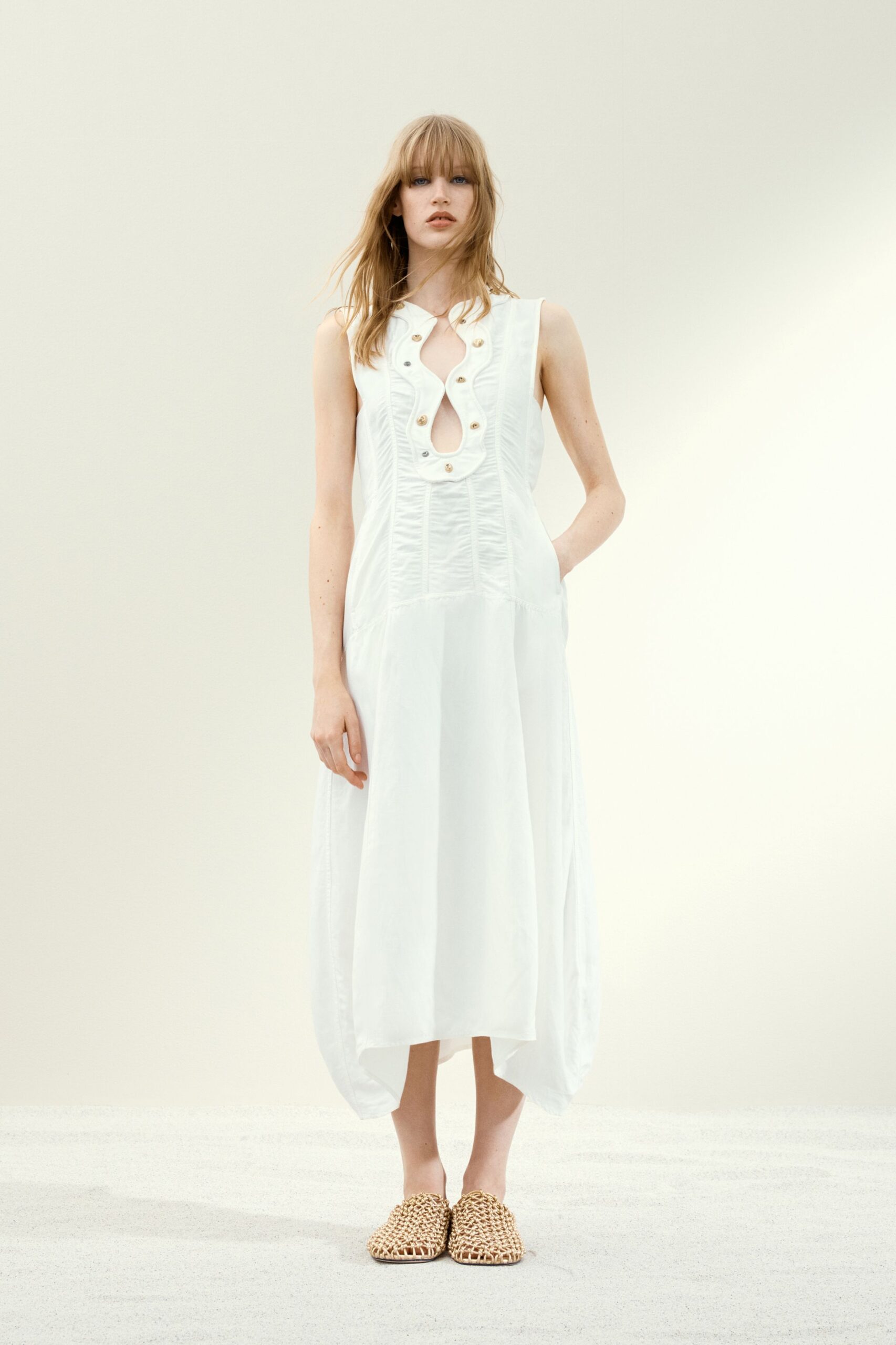 white cotton sleeveless v-neck fitted buttoned pleated dress