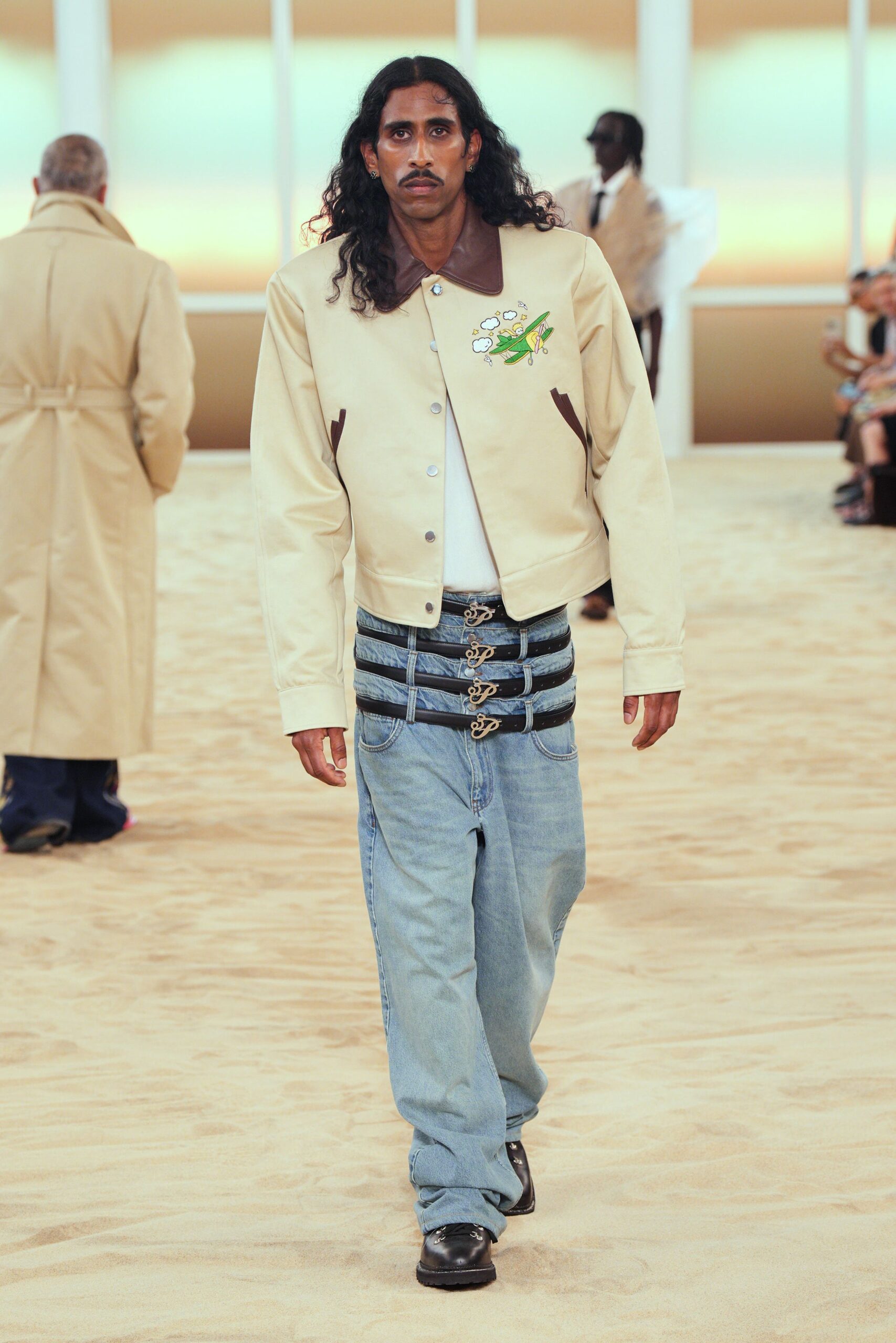 beige jacket white t-shirt blue pants black shoes