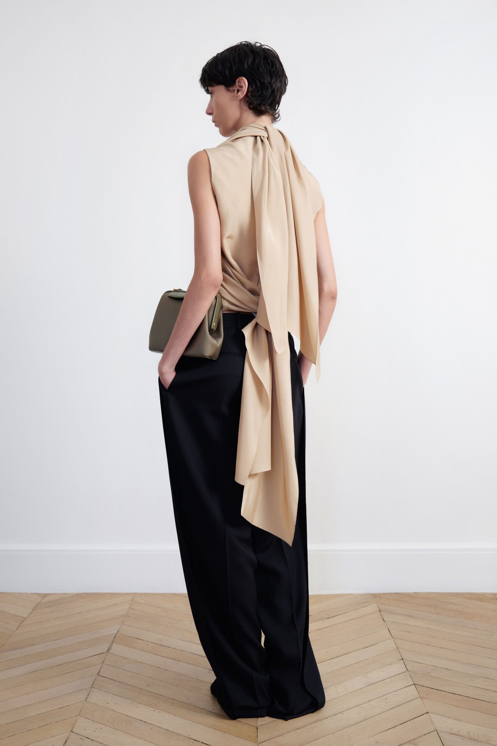 beige silk sleeveless top with black pants