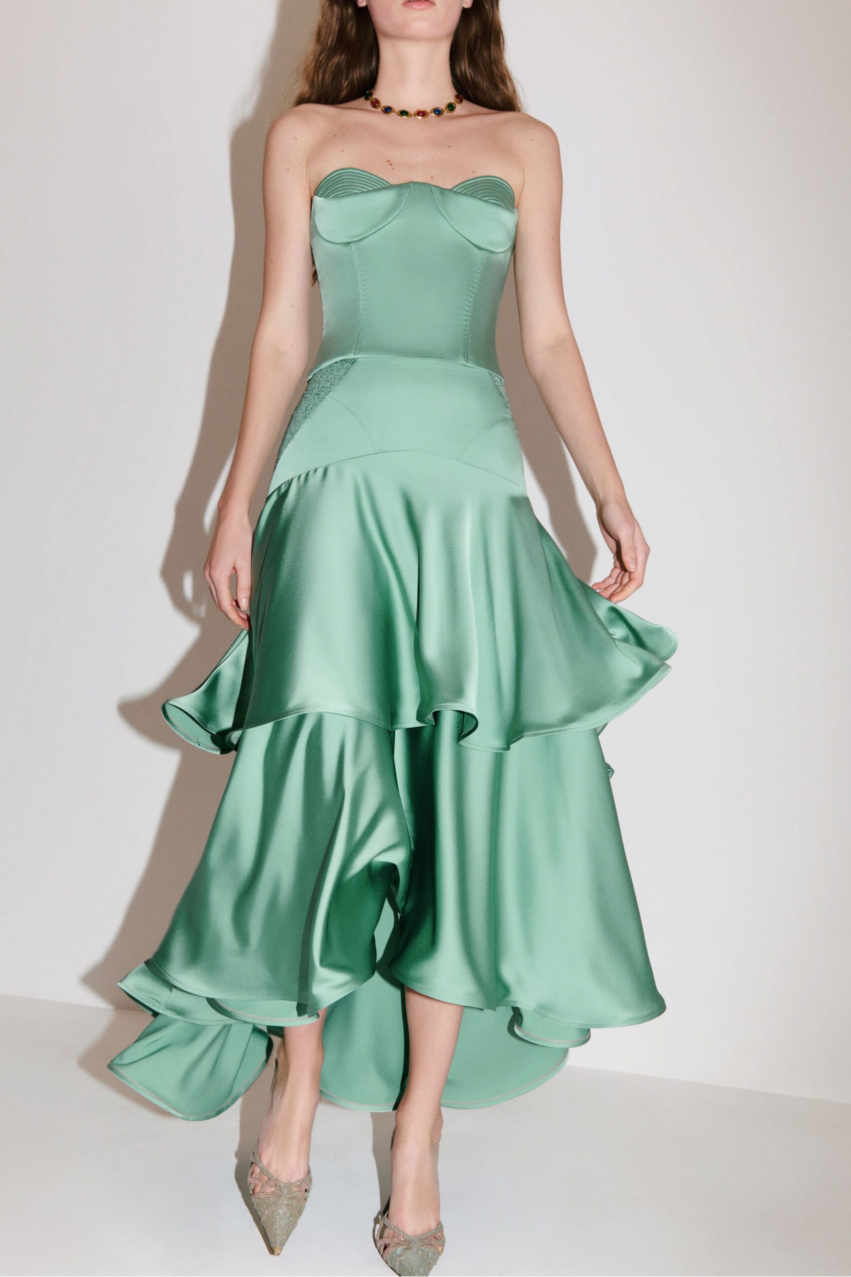 green satin strapless fitted ruffled flowing midi gown