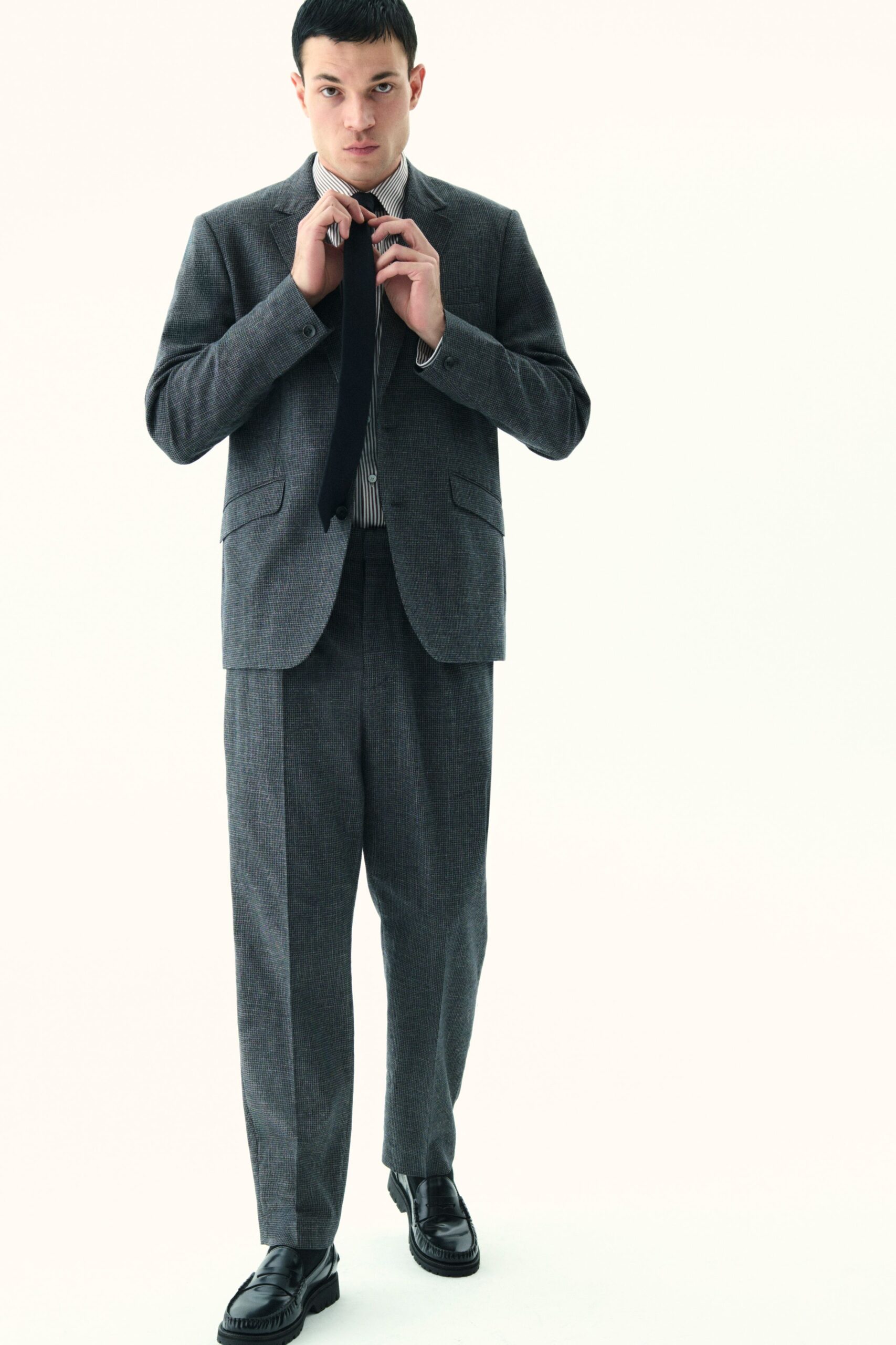 gray tailored suit with black tie