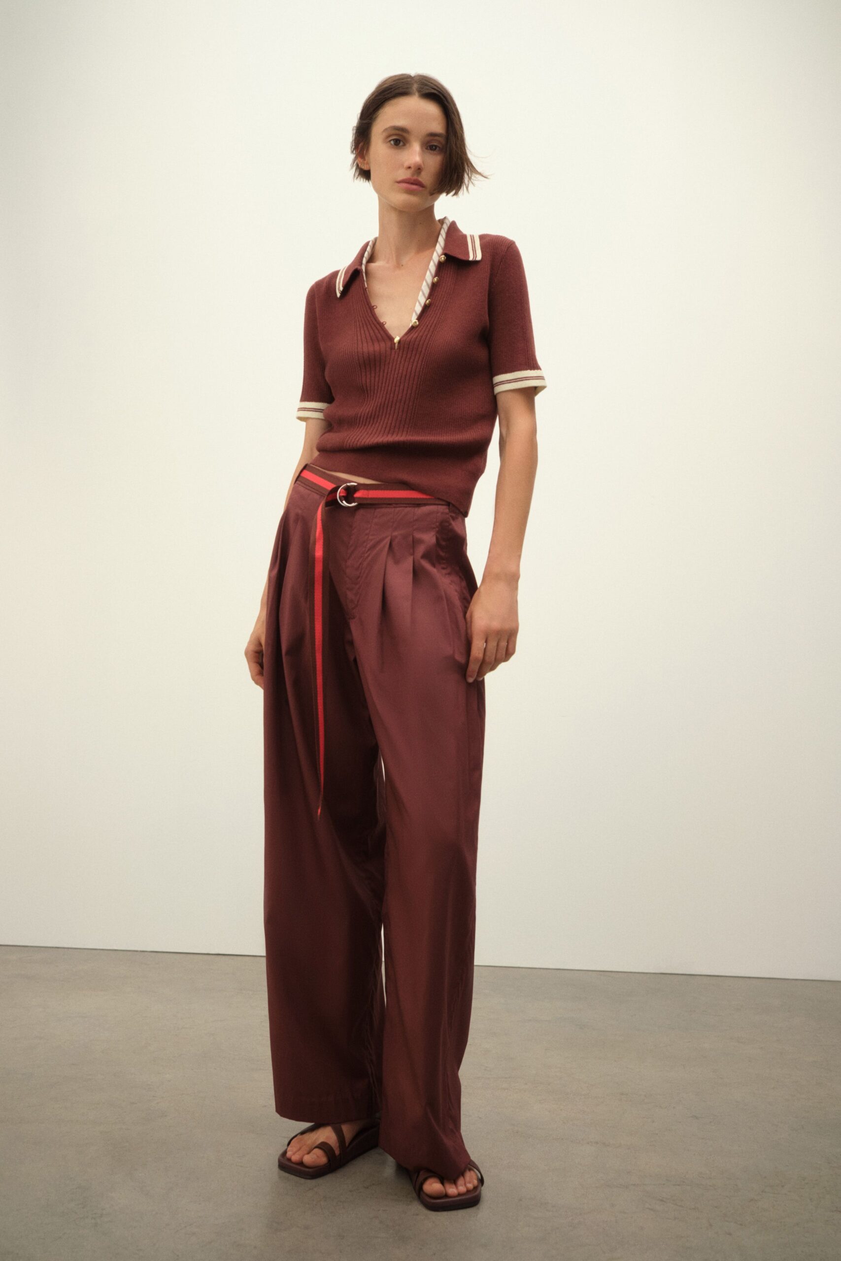 red fitted top with brown pants