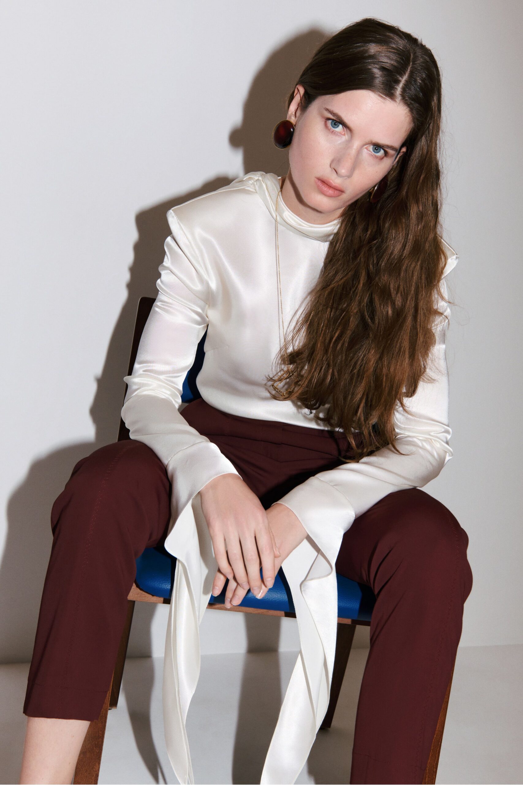 white silk fitted top and maroon pants