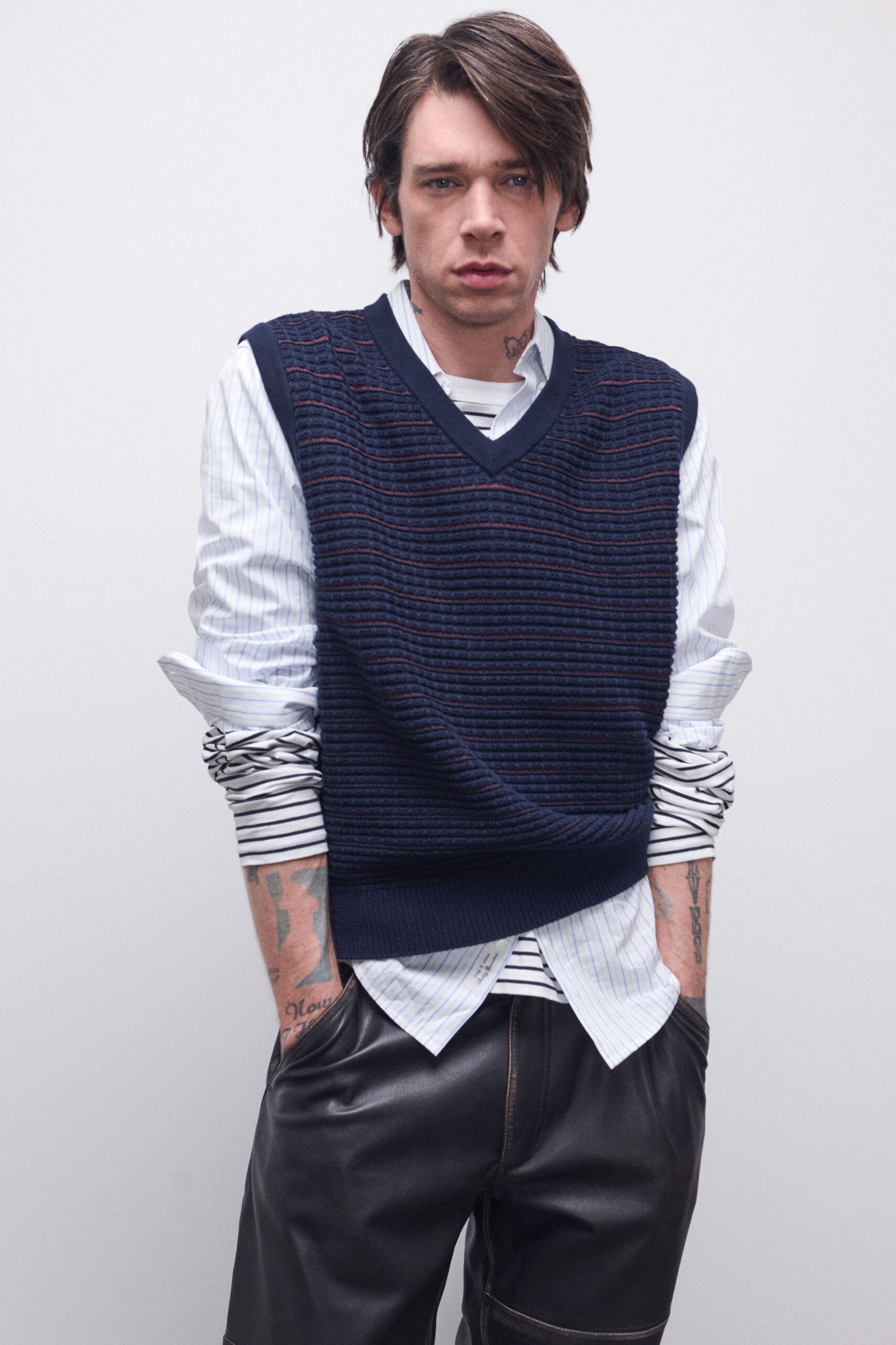 navy sweater over striped shirt and leather pants