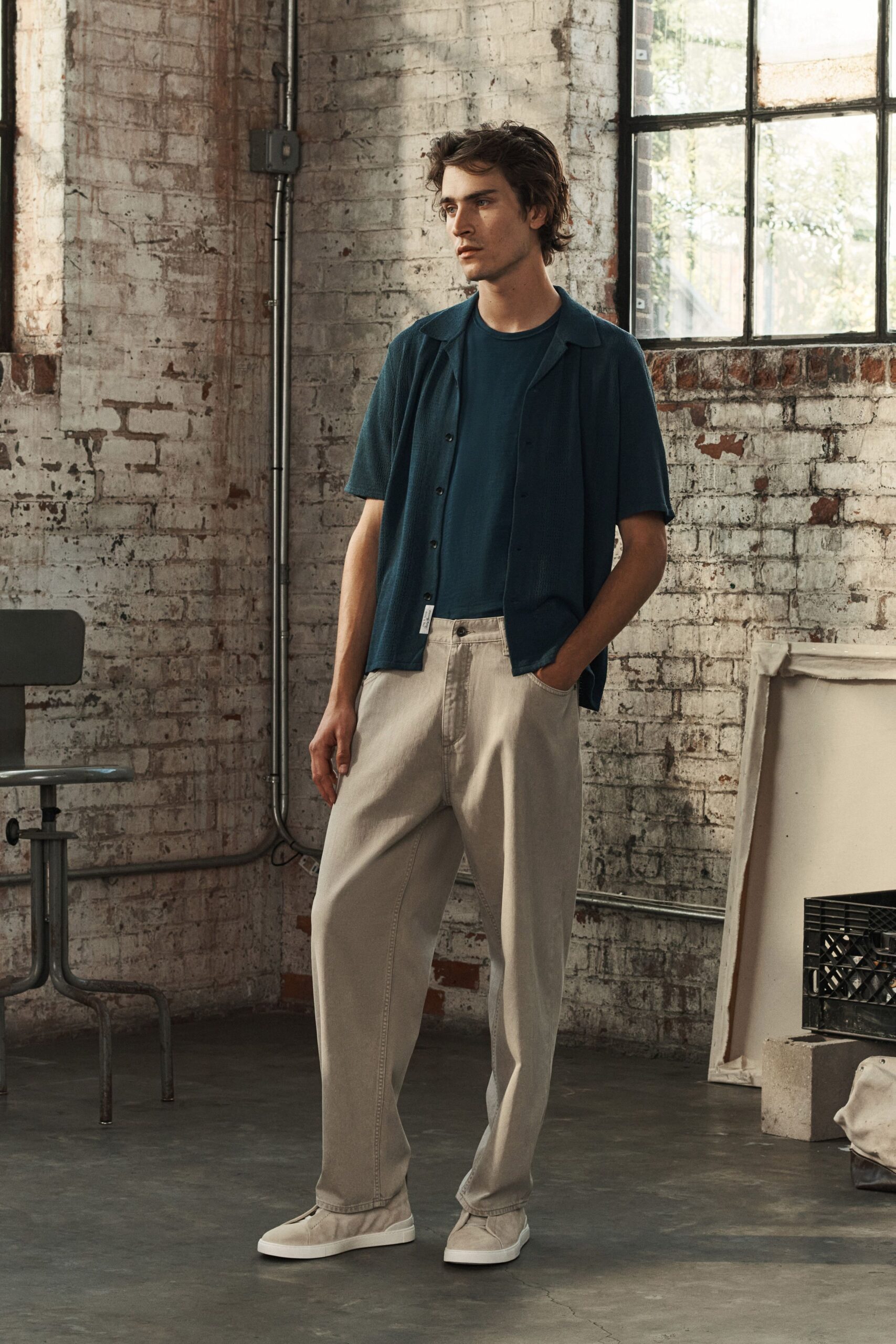 blue shirt black t-shirt beige pants white shoes