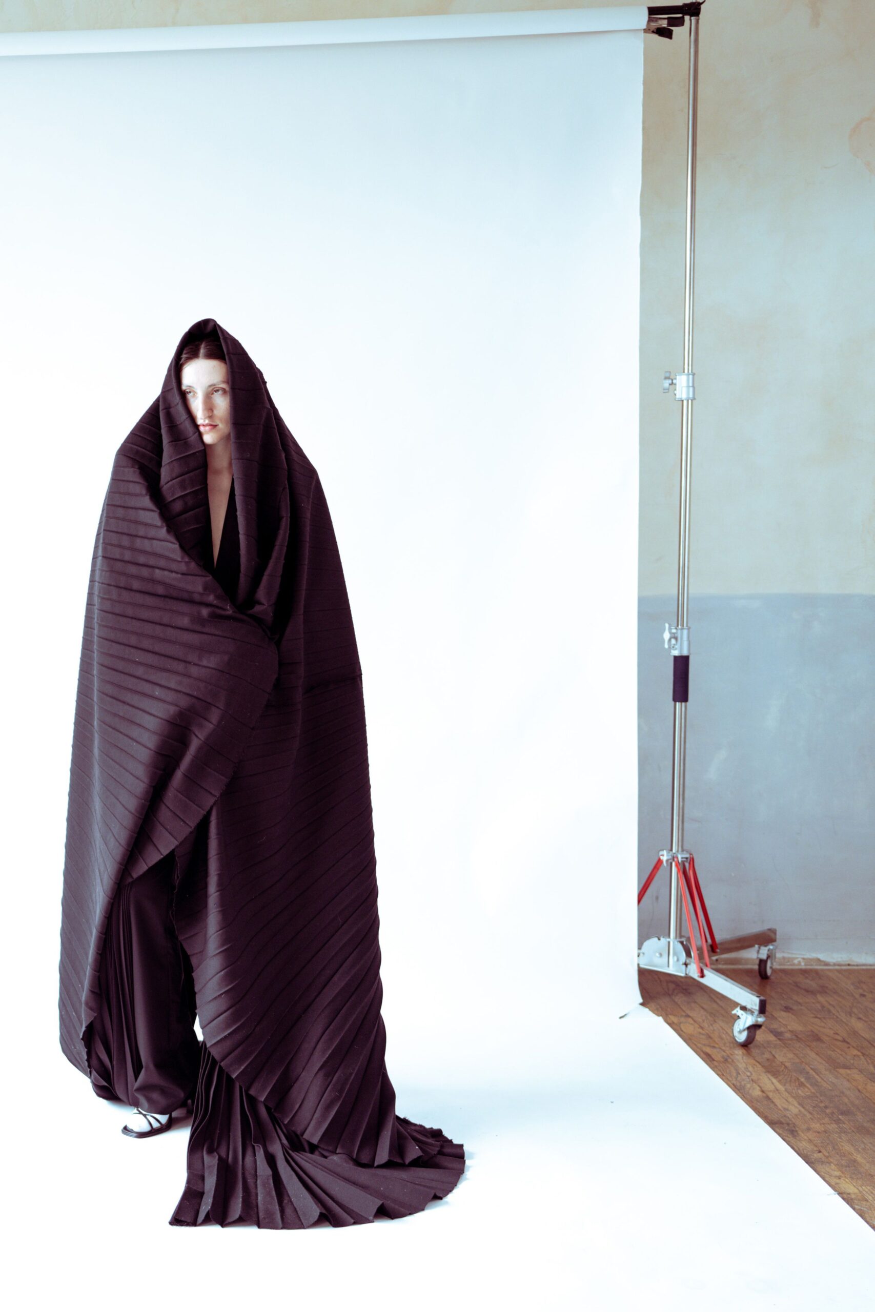 black pleated cape and fitted pants