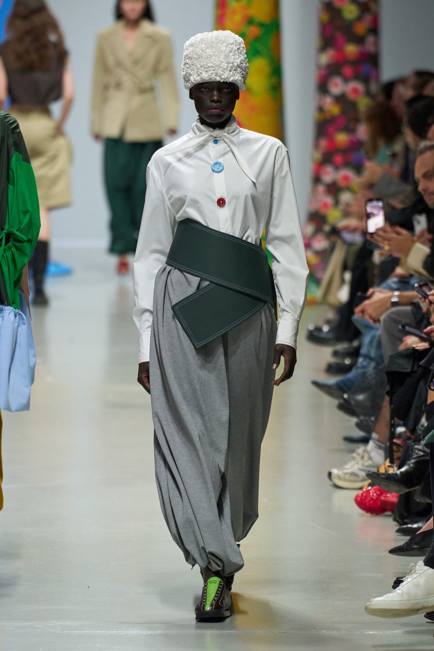 white shirt gray pants green accessories