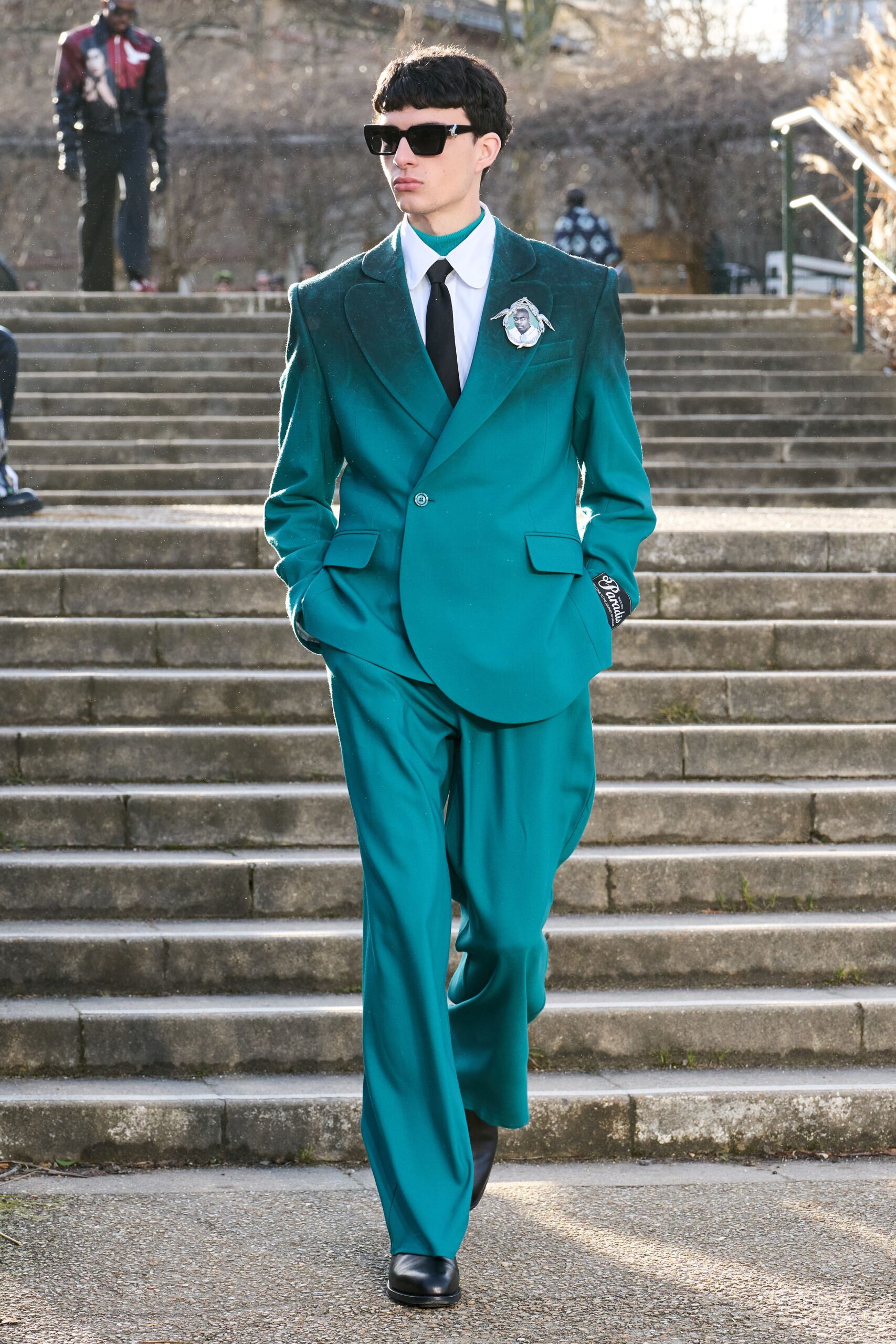 teal tailored suit with sunglasses